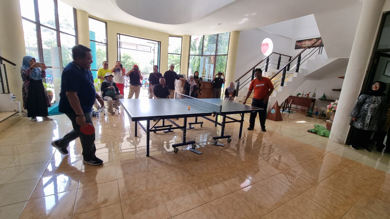 IKUT TANDING: Hadi Mulyono (kaos biru) Kepala Dinas Pendidikan Jember saat main tenis meja dengan Kepala SMPN 1 Giri, Banyuwangi. (Jumai/ Radarjember)
