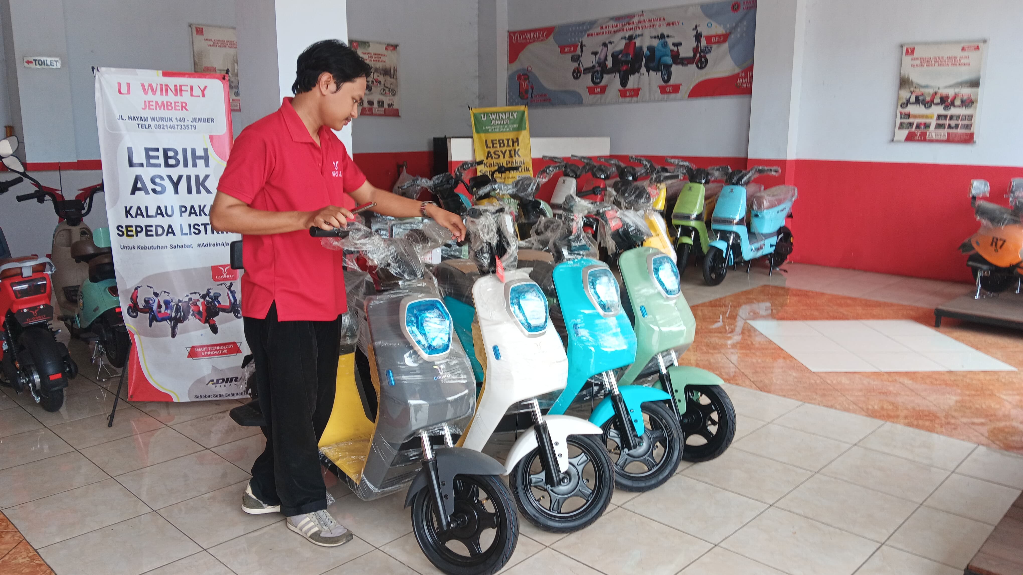 MENGECEK: Karyawan Dealer Uwinfly mengontrol sepeda listrik di diler daerah Mangli.