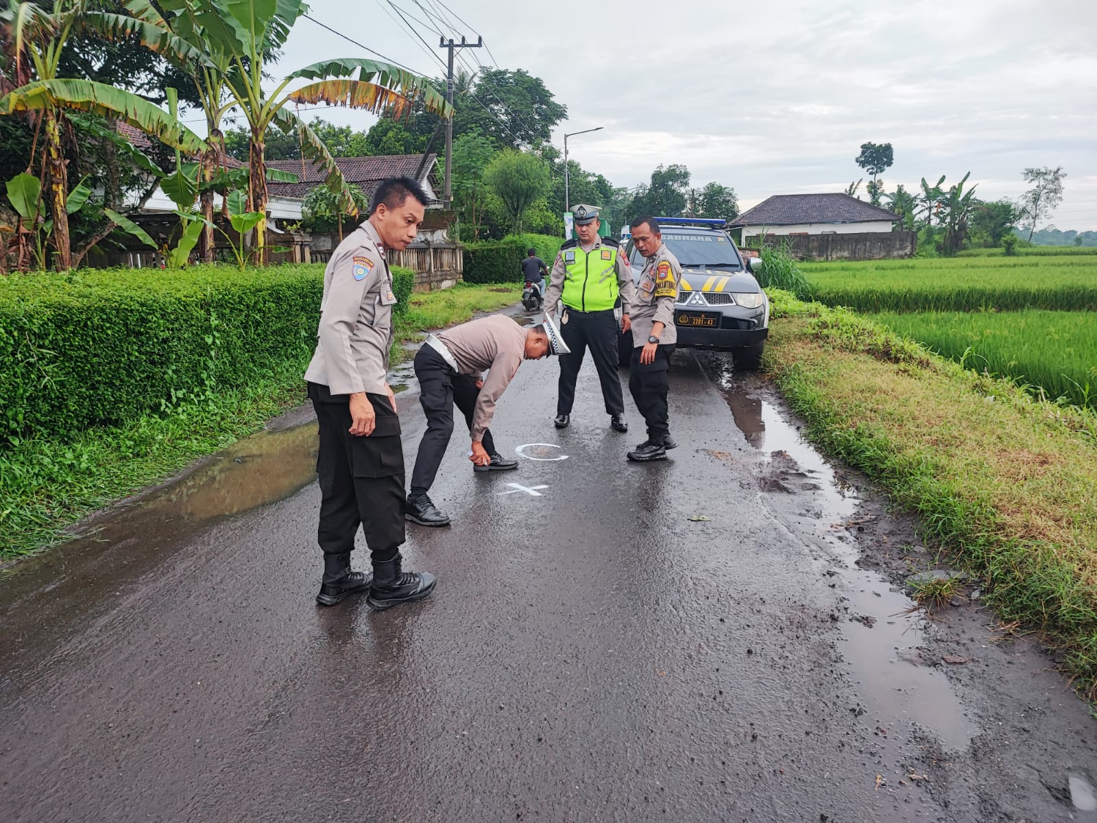 CEK LOKASI: Anggota Unit Lakalantas Satlantas Polres Jember bersama anggota Polsek Pakusari melakukan olah TKP di Jalan Desa Subo, Kecamatan Pakusari.(POLSEK PAKUSARI UNTUK RJ)