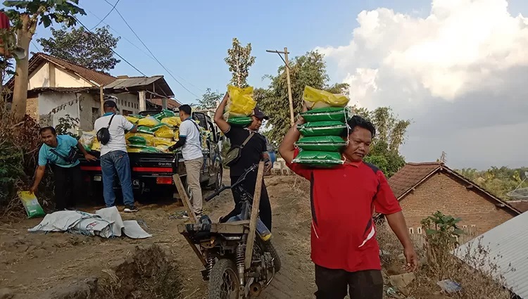 GOTONG BERAS: Seorang warga yang tinggal di pelosok Desa Kabuaran, Kecamatan Grujugan, saat membawa beras dari pasar murah. Tahun ini anggaran dana desa di Bondowoso naik Rp 2 miliar.