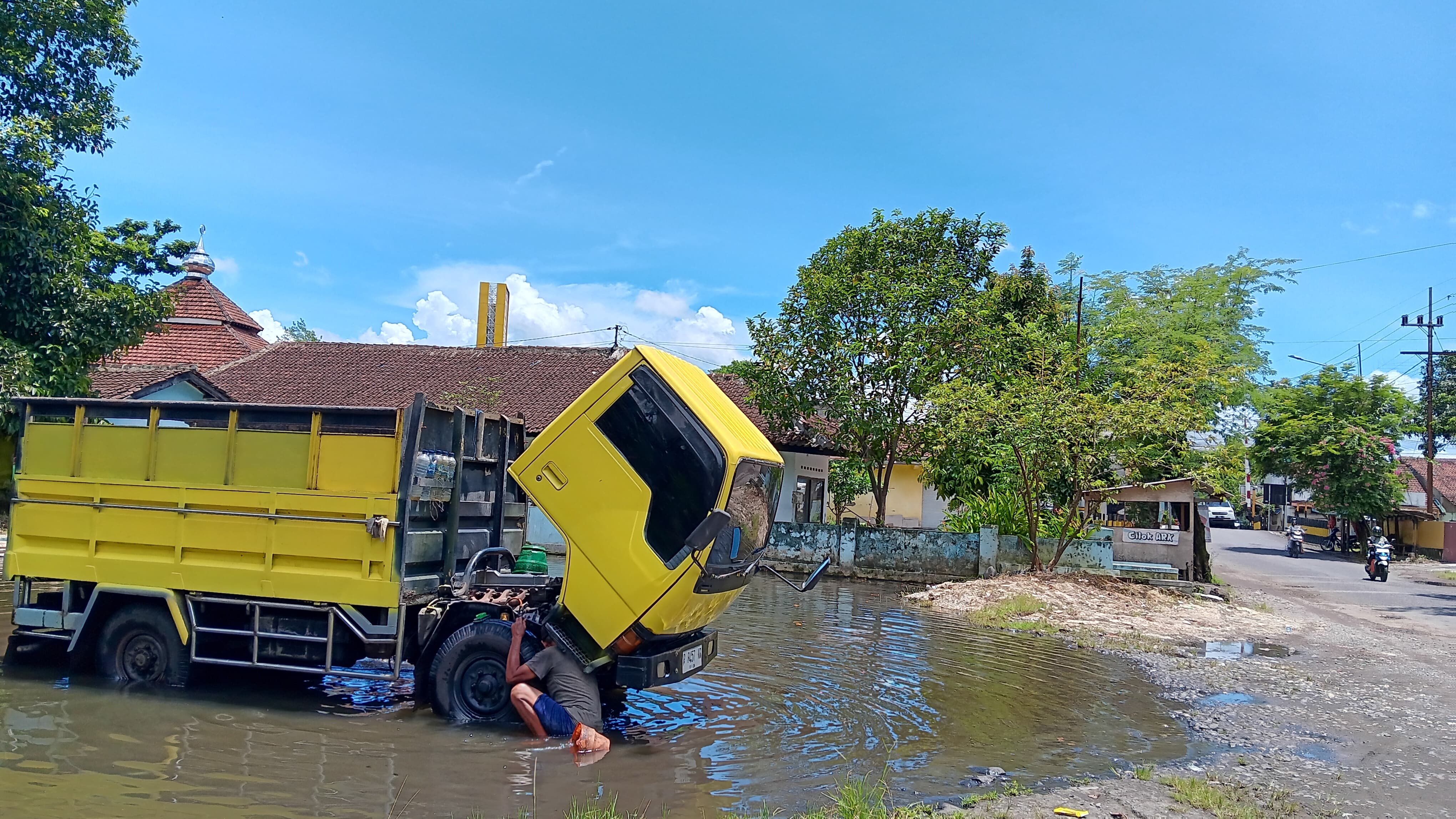 MENIKMATI: Abdur Rozaq telaten membersihkan truk di kolam genangan air Sempusari, Kaliwates. (M ADHI SURYA / RADAR JEMBER)