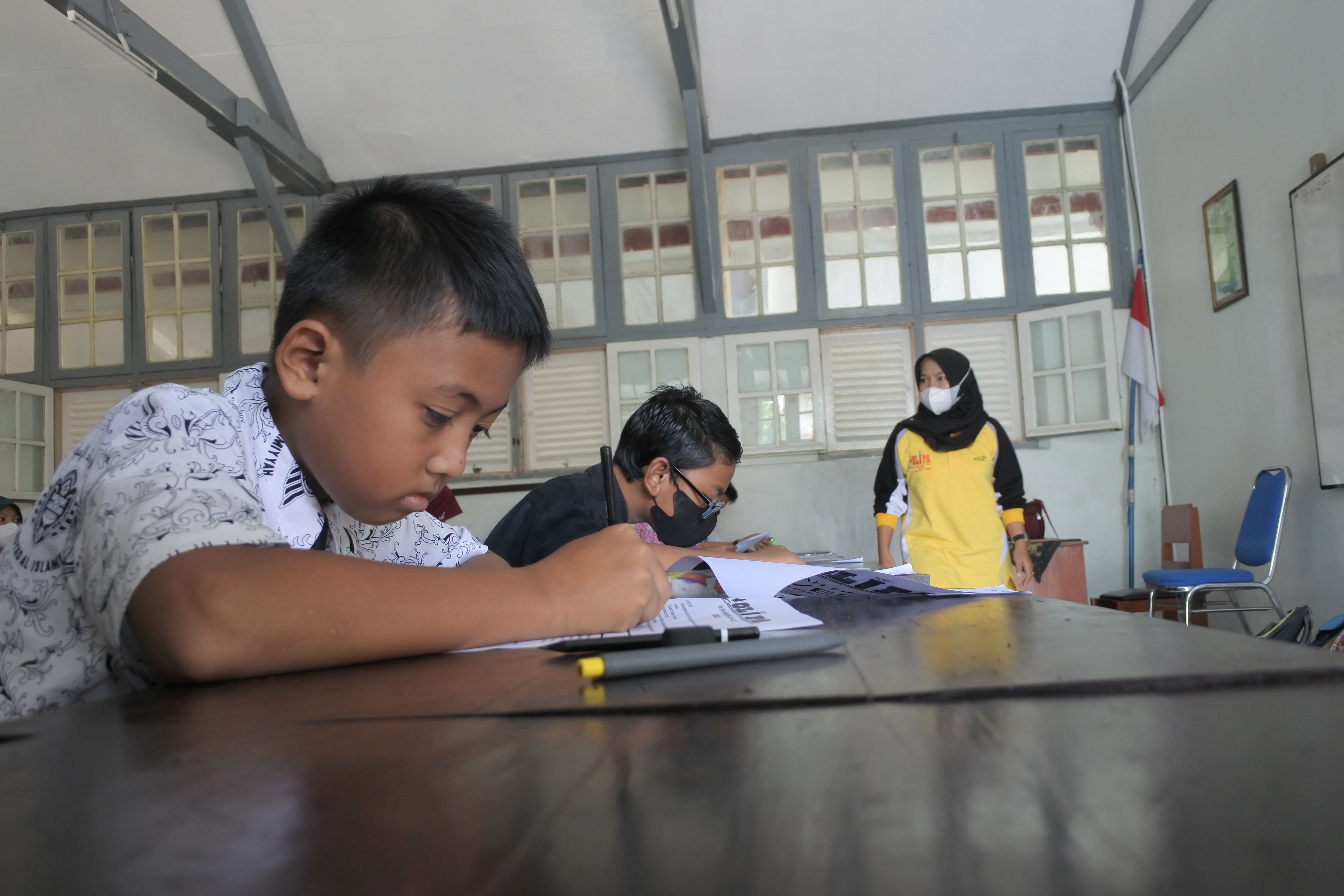 FOKUS: Guru sedang membagikan lembaran soal kepada siswa di SMPN 1 Jember.AZZQAL AZQIYA&rsquo;/RADAR JEMBER
