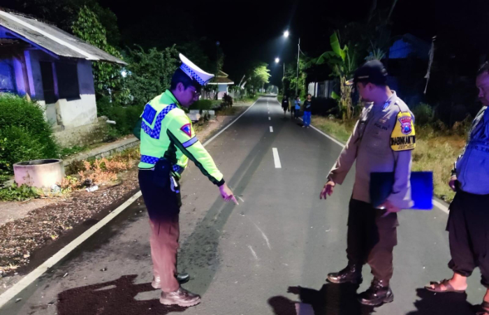 DATANGI LOKASI: Anggota Unit Laka Lantas Polres Jember melakukan olah TKP kecelakaan yang melibatkan dua pengendara sepeda motor di Jalan Panti, Minggu (18/2) dini hari. (SATLANTAS POLRES JEMBER)