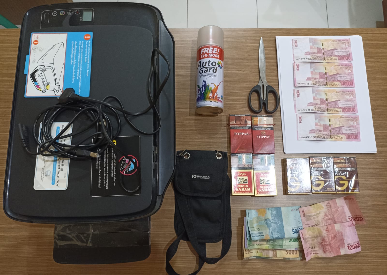 AMANKAN BB: Satreskrim Polsek Sumbersari saat mengamankan barang bukti berupa mesin printer, uang, rokok dan barang bukti lainnya yang diamankan dari tangan tersangka. (Polsek untuk RadarJember.id)