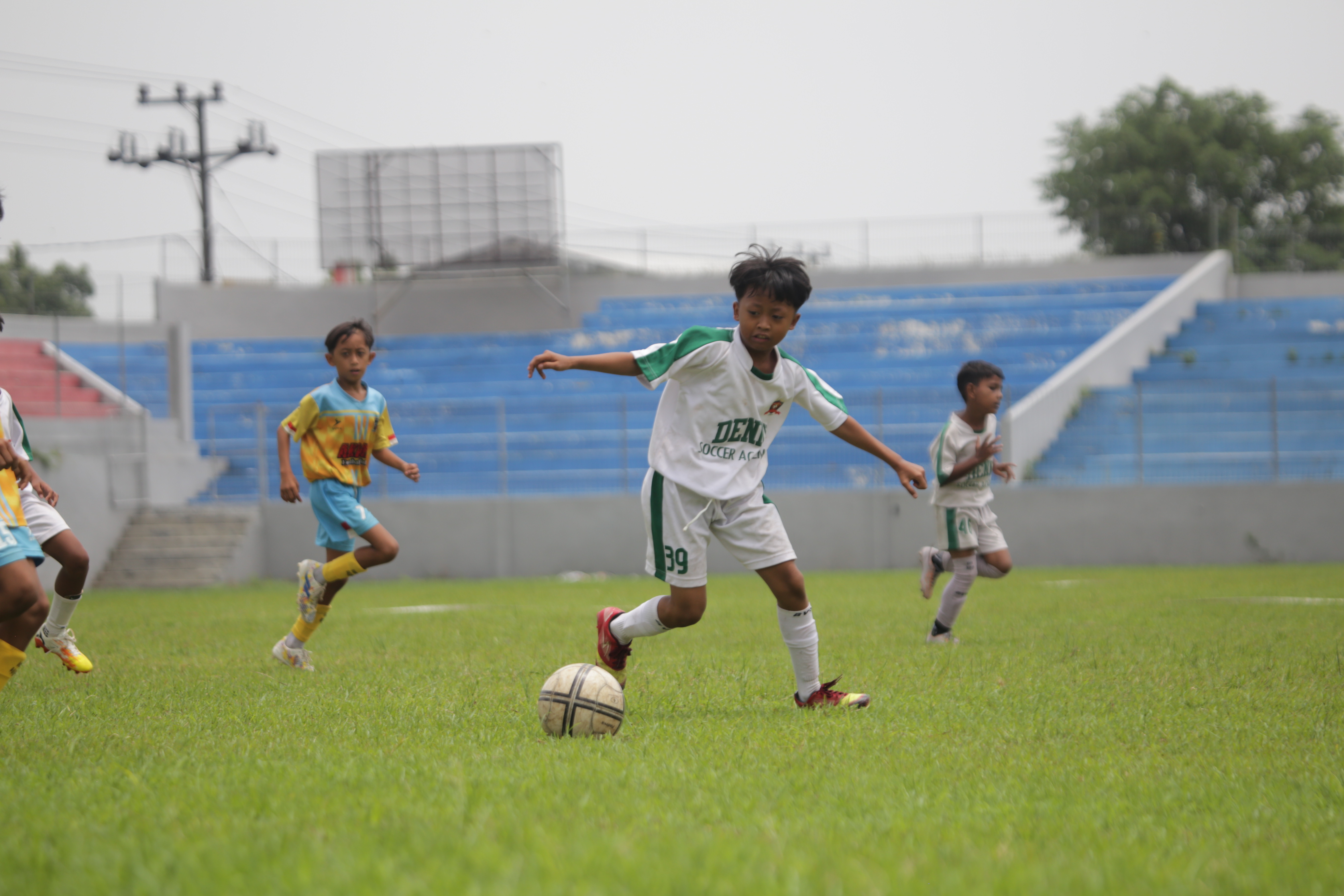 SENGIT: Pemain cilik U10 Denny Soccer Academy menggiring bola ke arah gawang lawan, Kemarin (24/2).(YULIO FARUQ AKHMADI/RADAR JEMBER)