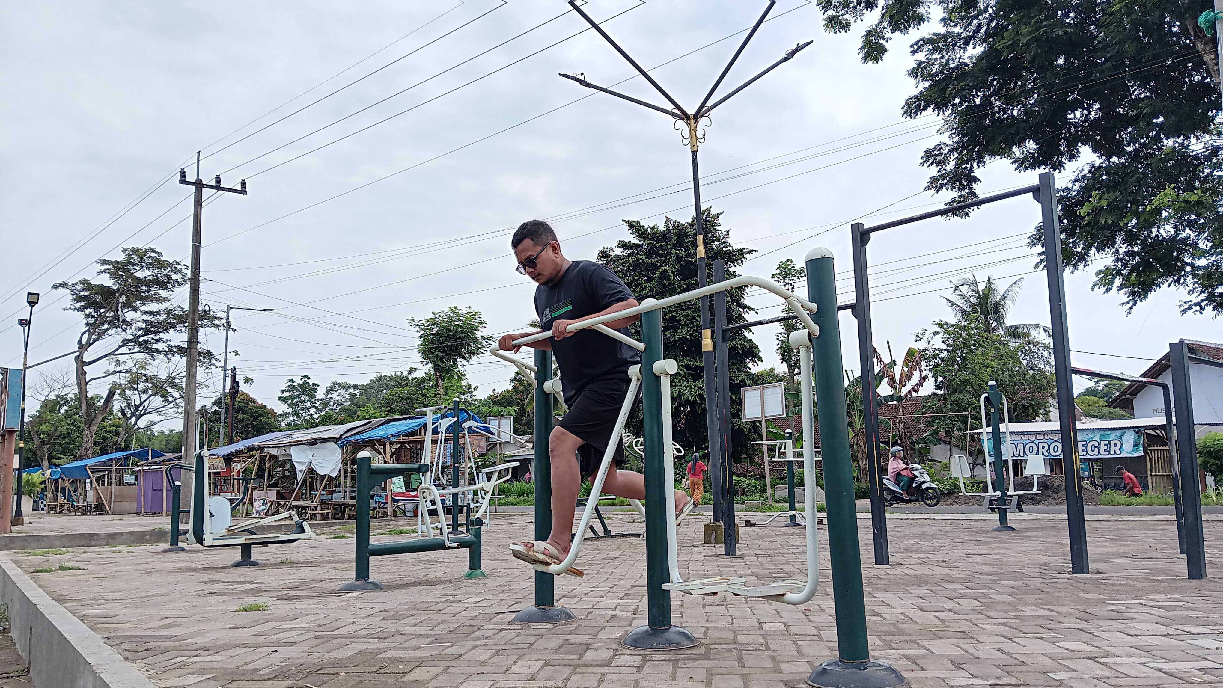 OLAHRAGA: Zainul Anam, warga setempat, menikmati fasilitas gym outdoor di RTH Desa Jatimulyo, Kecamatan Jenggawah.