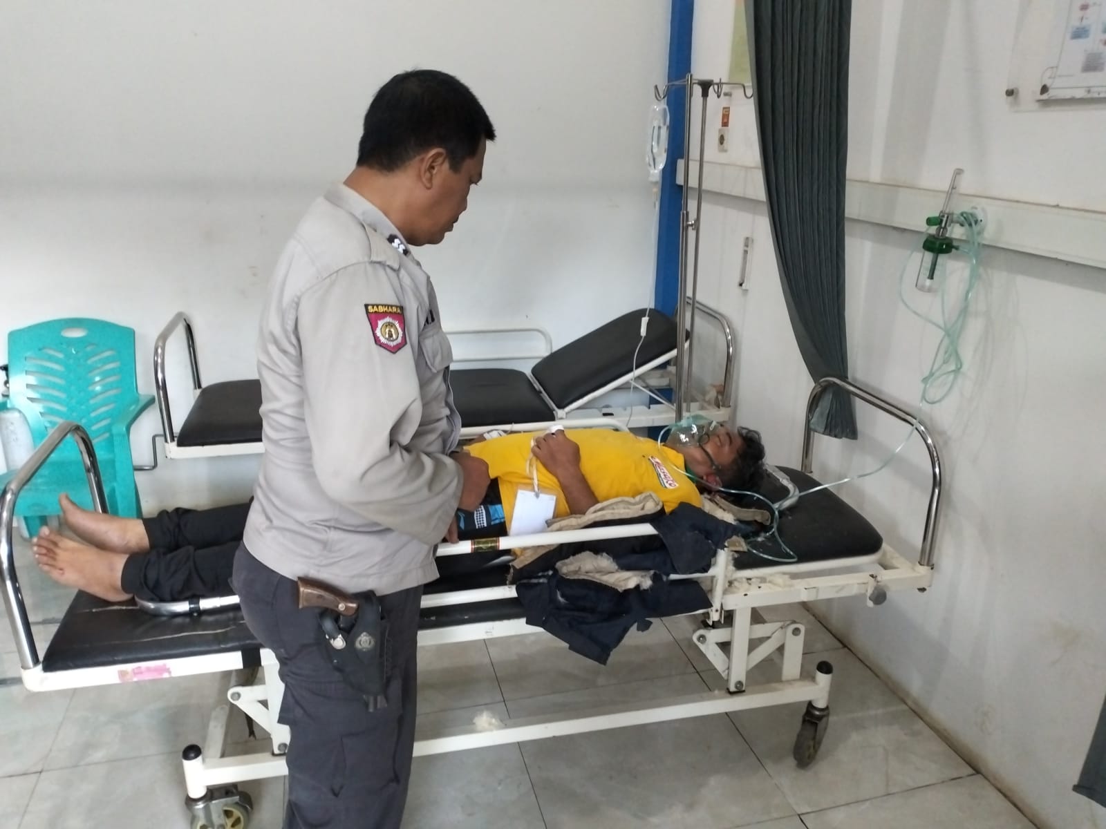 DIRAWAT: Anggota kepolisian mengecek kondisi Yoyok Santoso saat dirawat di Puskesmas Jelbuk. Pria 45 tahun warga Kepatihan ini pun meninggal dunia akibat kecelakaan tunggal, kemarin (4/3). (POLSEK JEL