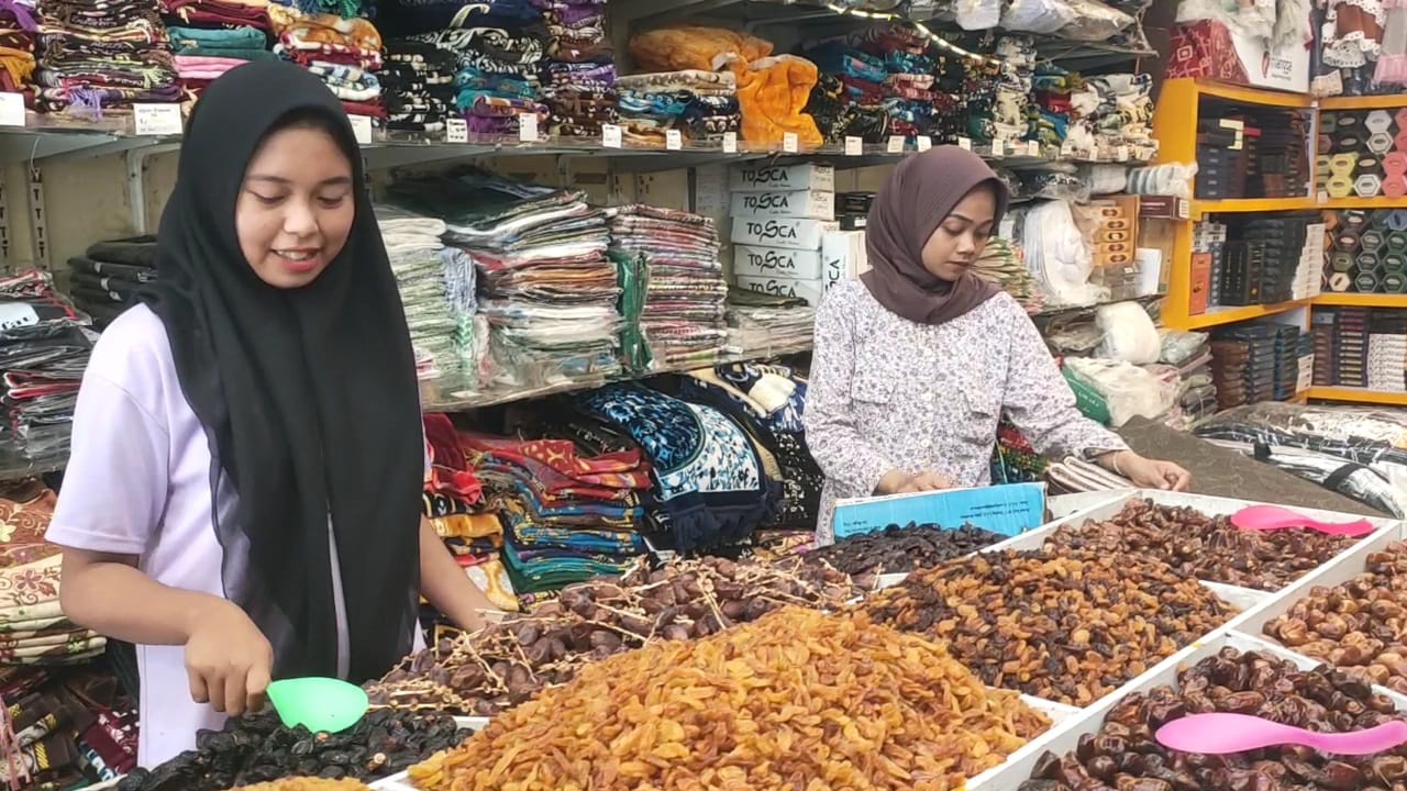 BERJUALAN: Karyawan menyiapkan kurma untuk pembeli di Pasar Tanjung, Jember, kemarin (6/3).(M ADHI SURYA/RADAR JEMBER)
