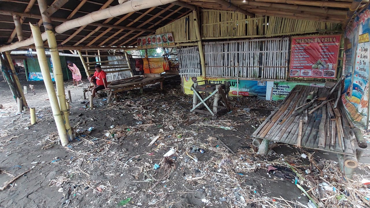 KEMASUKAN SAMPAH: Pasangnya air laut yang besar pada Rabu (13/3/2024) mengakibatkan warung dipinggir pantai Payangan Dusun Watu Ulo, Desa Sumberejo, Kecamatan Ambulu rusak. (JUMAI/RJ)