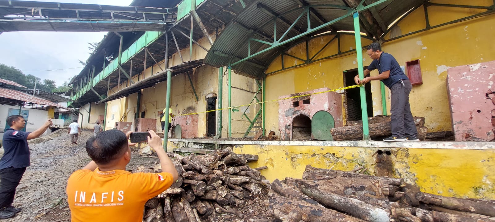 PASANG GARIS POLISI: Anggota Polsek Tanggul bersama tim Labfor Pplda dan tim Inafis Polres Jember memasang Police Line di lokasi kebakaran Senin (8/4/2024). (JUMAI/RJ)