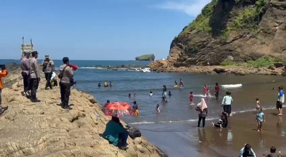 BERIKAN HIMBAUAN: Anggota Polsek Ambulu bersama tim SAR saat menghimbau kepada pengunjung wisata Watu Ulo dengan menggunakan megaphone. (Jumai/ radarjember)