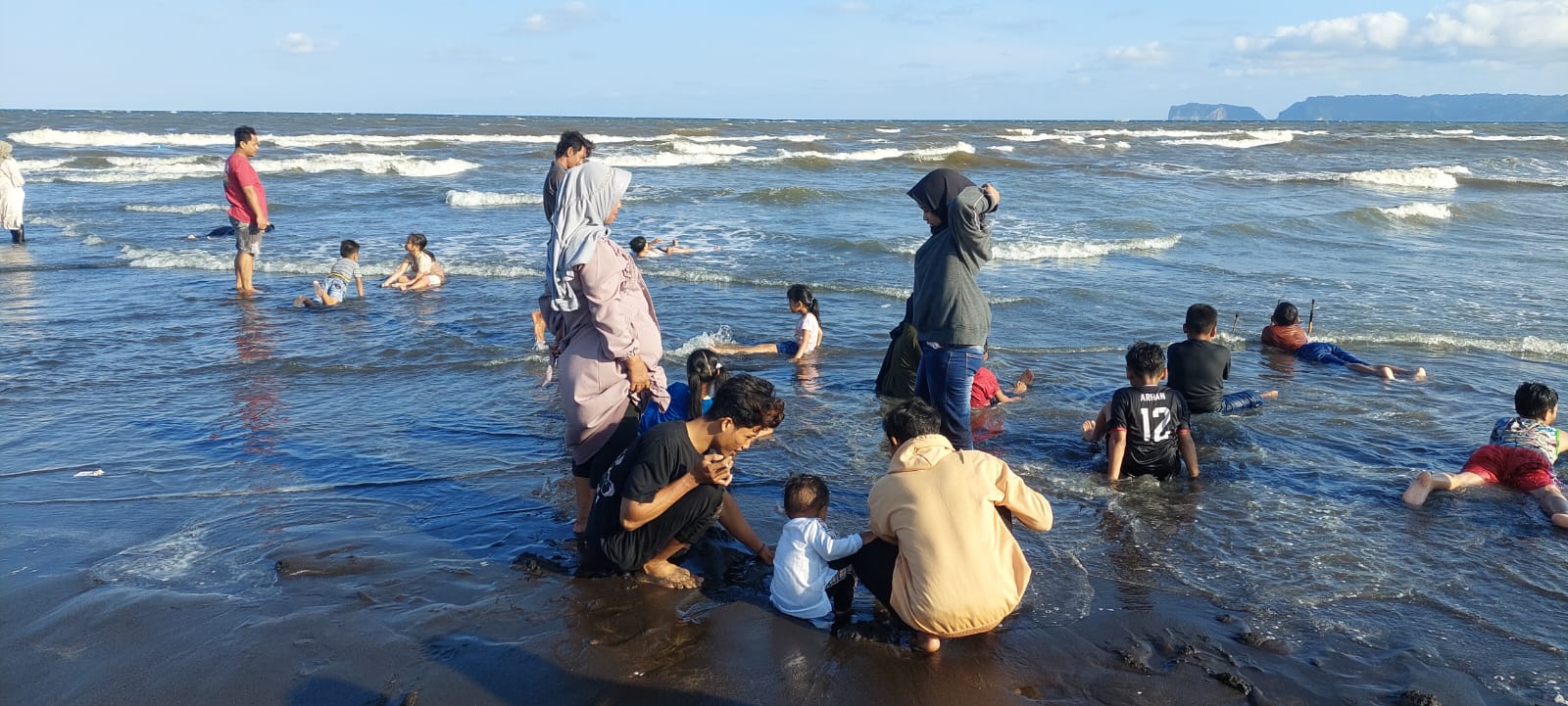 MASIH MANDI: Wisatawan yang berkunjung ke pantai Cemara, Dusun Getem, Desa Mojomulyo, Kecamatan Puger, Jember masih saja tetap mandi bersama pengunjung lainnya. (JUMAI/RJ)