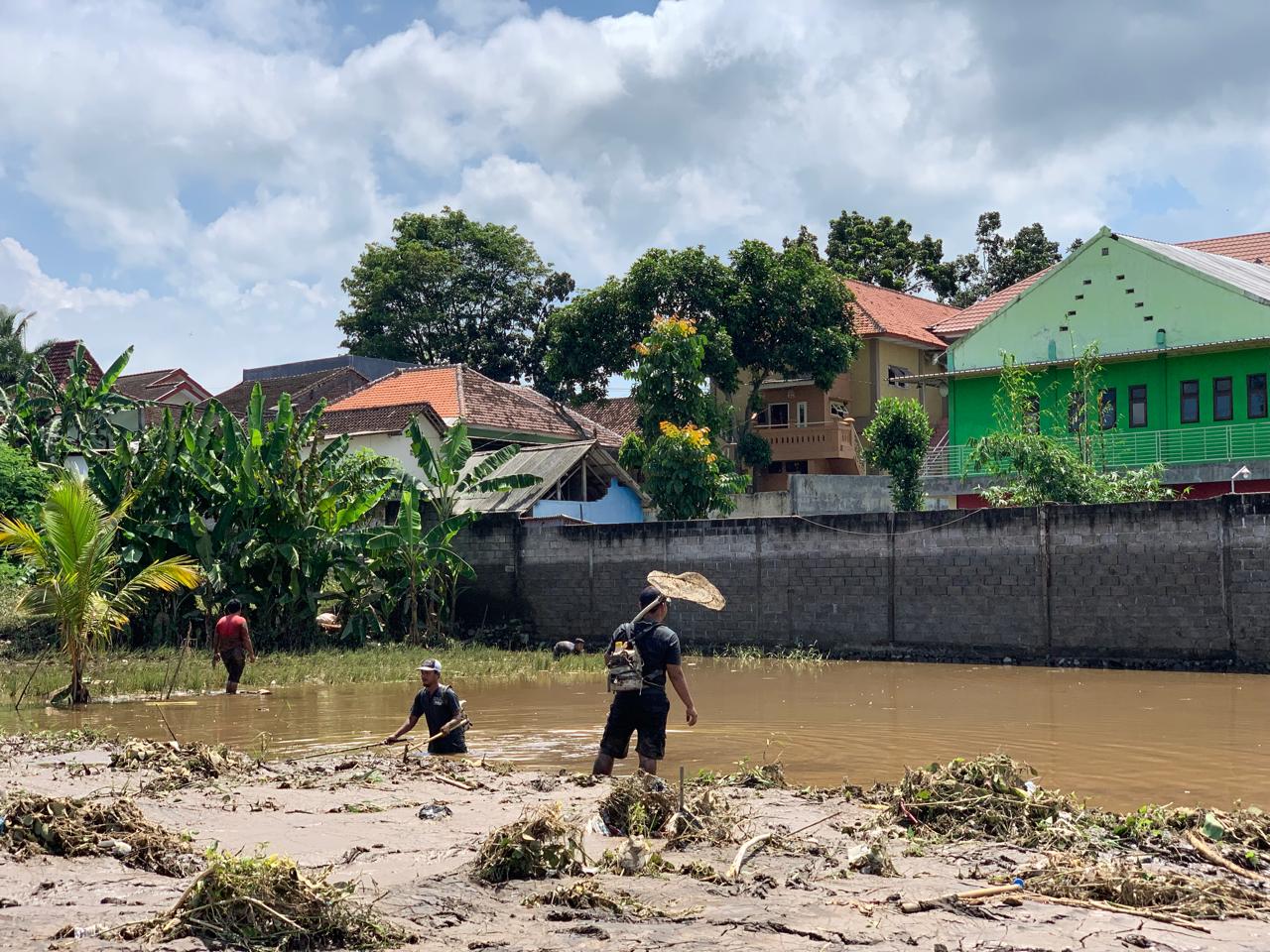DAPAT BANYAK: Warga memanfaatkan banjir untuk mencari ikan di area persawahan. (ADE APRYANIS/RADAR SEMERU)