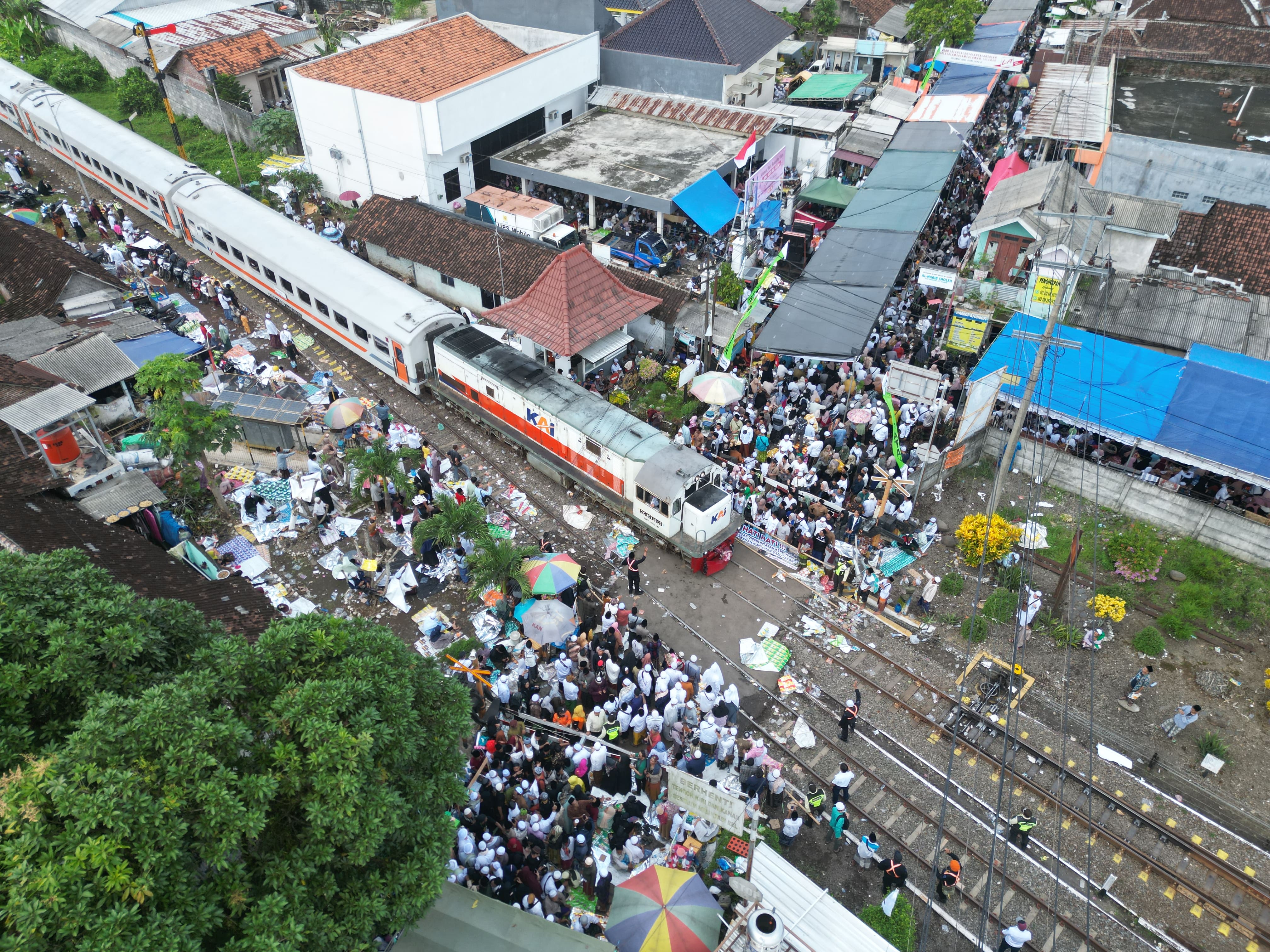 MELINTAS: Foto dari udara, kereta api lewat di tengah-tengah kerumunan para peziarah Haul Habib Sholeh.