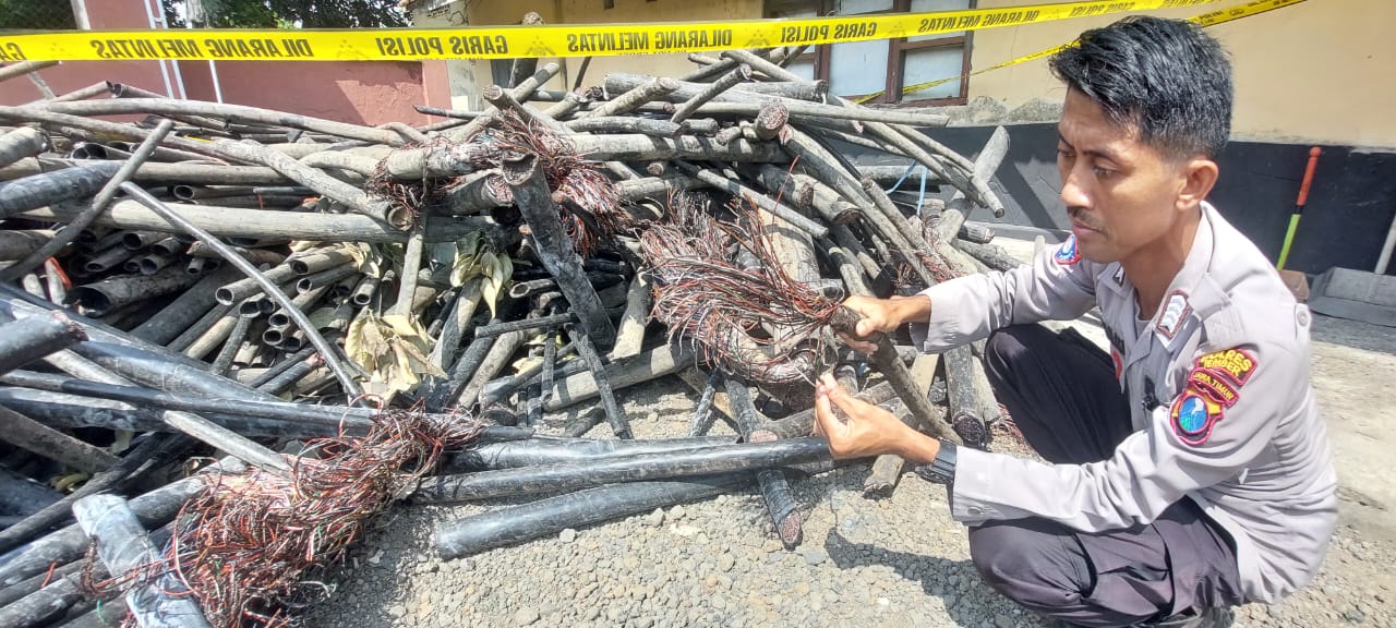 BARANG BUKTI: Anggota Polsek jenggawah saat menunjukkan potongan kabel yang diamankan dari rumah kontrakan yang dijadikan tempat menimbun potongan kabel milik telkom. (JUMAI/RJ)