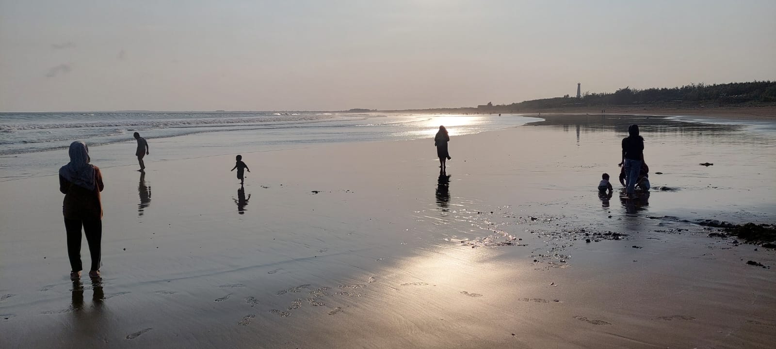 JADI TEMPAT SWAFOTO: Banyak warga yang datang ke Pantai Pancer, Puger, untuk berswafoto dengan memanfaatkan air laut surut dan matahari terbenam. (JUMAI/RJ)