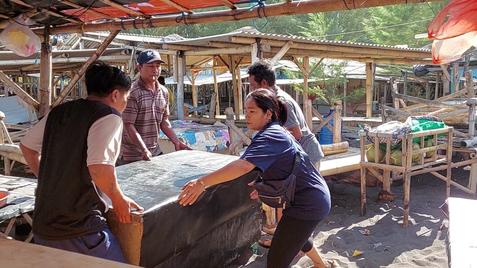 SELAMATKAN BARANG BARANG: Pemilik warung saling membantu untuk memindah meja tempat jualan setelah terjadi gelombang besar pada Jumat (7/6/2024). (JUMAI/RJ)
