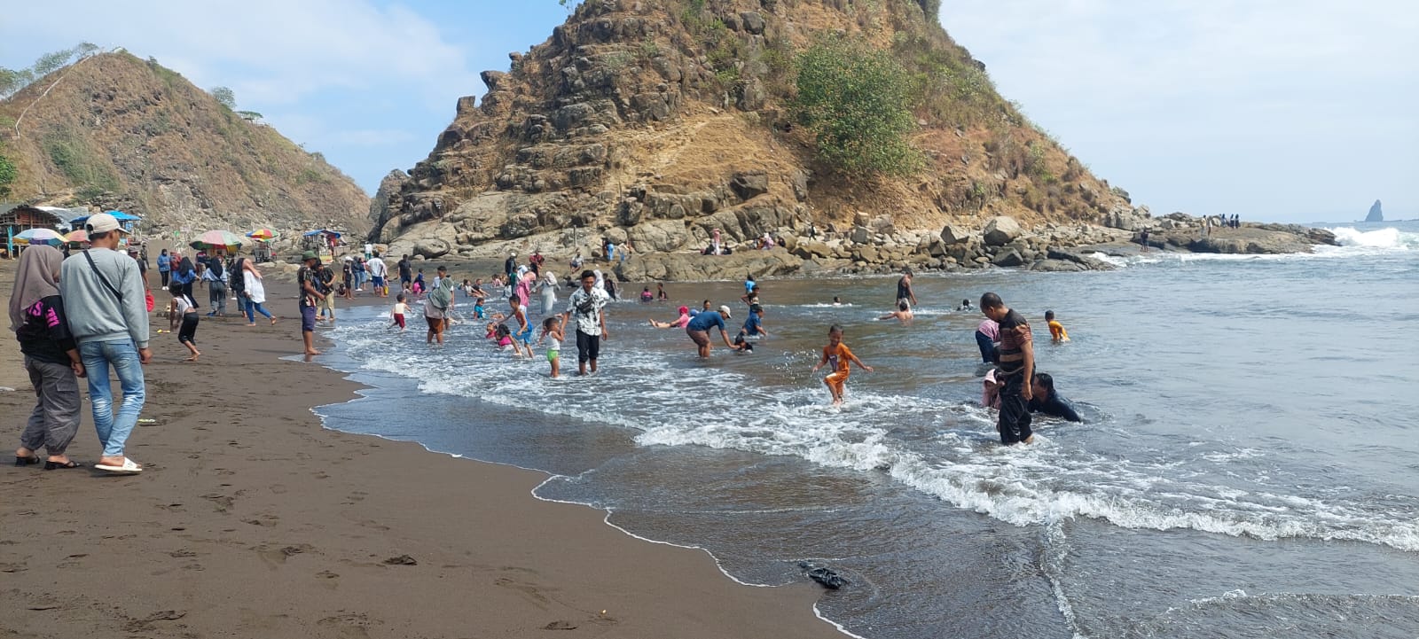 ABAIKAN HIMBAUAN: Pengunjung pantai Payangan, Dusun Watu Ulo Desa Sumberejo, Kecamatan Ambulu, Jember masih saja tetap mandi. (Jumai/radarjember)