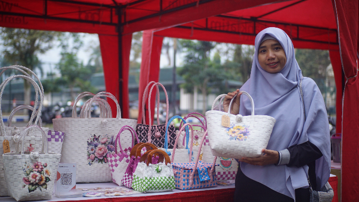 UNIK: Pelaku UMKM, Ajeng Wulan Kinasih, menunjukkan produk kerajinan tas anyaman berbahan plastik strapping band yang diminati hingga pasar luar negeri. YULIO FA/RADAR JEMBER