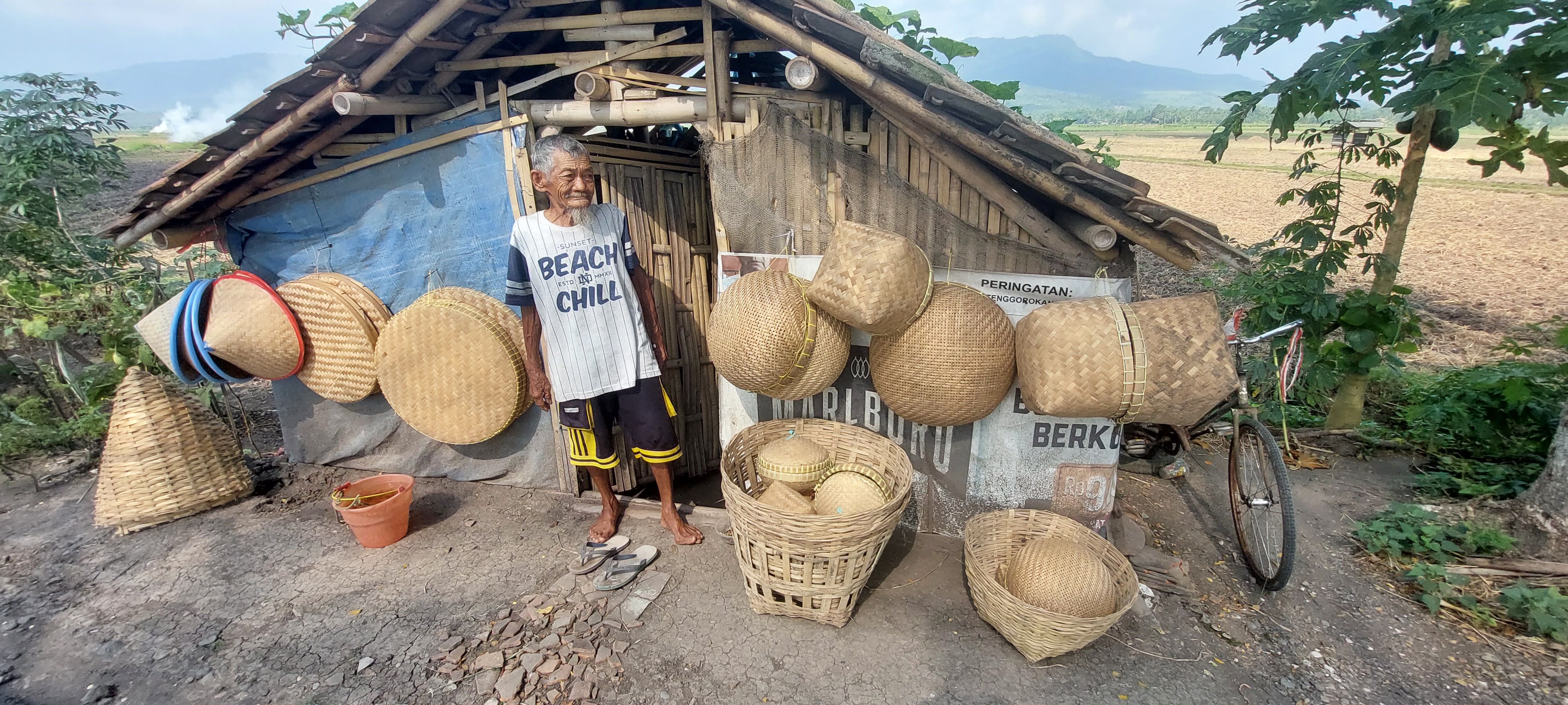 SEMANGAT: Kakek Miskan, warga Desa Dukuhdempok, Kecamatan Wuluhan, bertahan hidup dengan karya kerajinan bambu di gubuk pinggir jalan Dusun Kepel, Desa Ampel, Kecamatan Wuluhan.