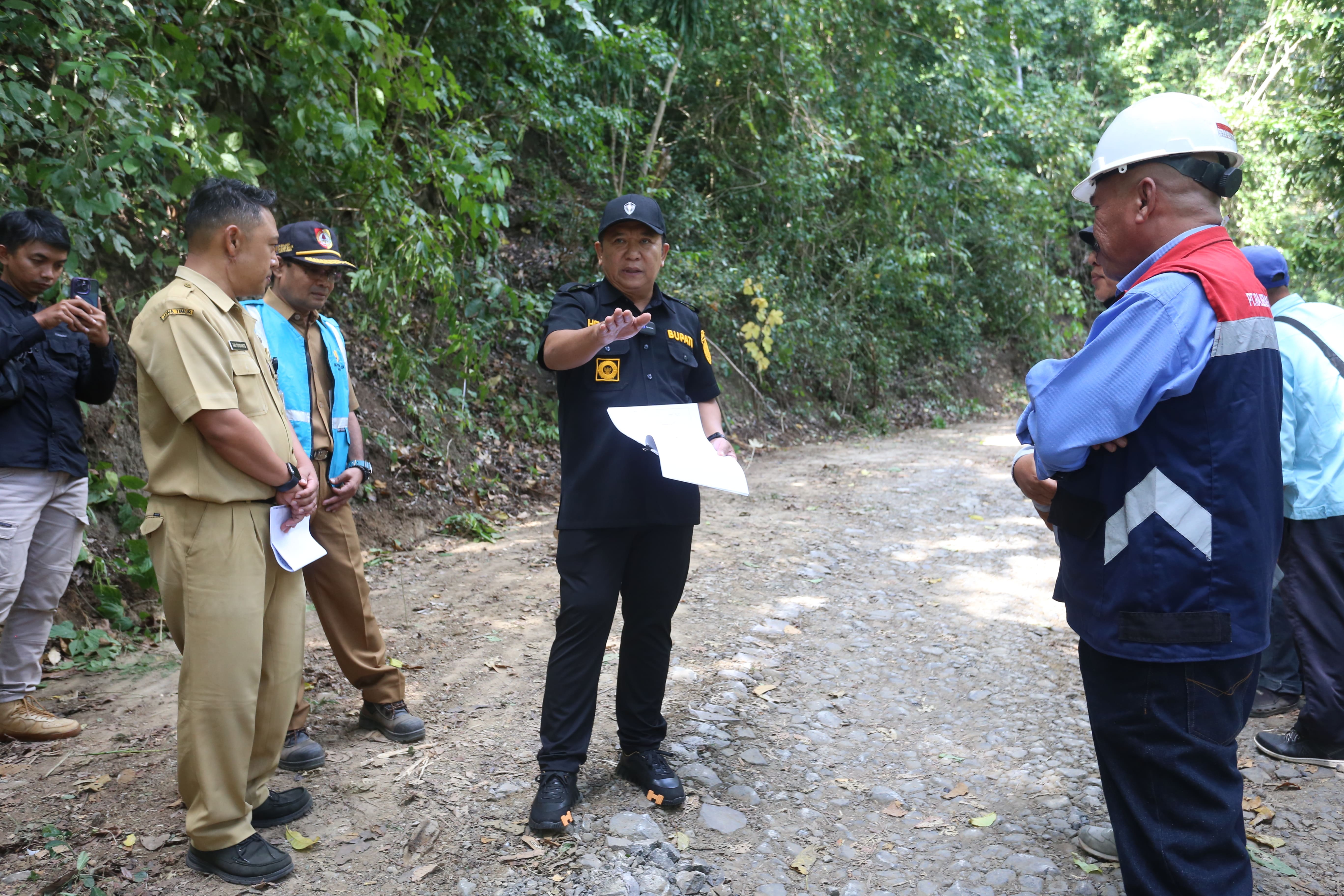 BERI PENGARAHAN: Bupati Jember Hendy Siswanto meninjau proses pembangunan jalan di Dusun Bandealit, Desa Andongrejo, Kecamatan Tempurejo, Senin (1/7) siang.(AZZQAL AZQIYA&rsquo;/RADAR JEMBER)