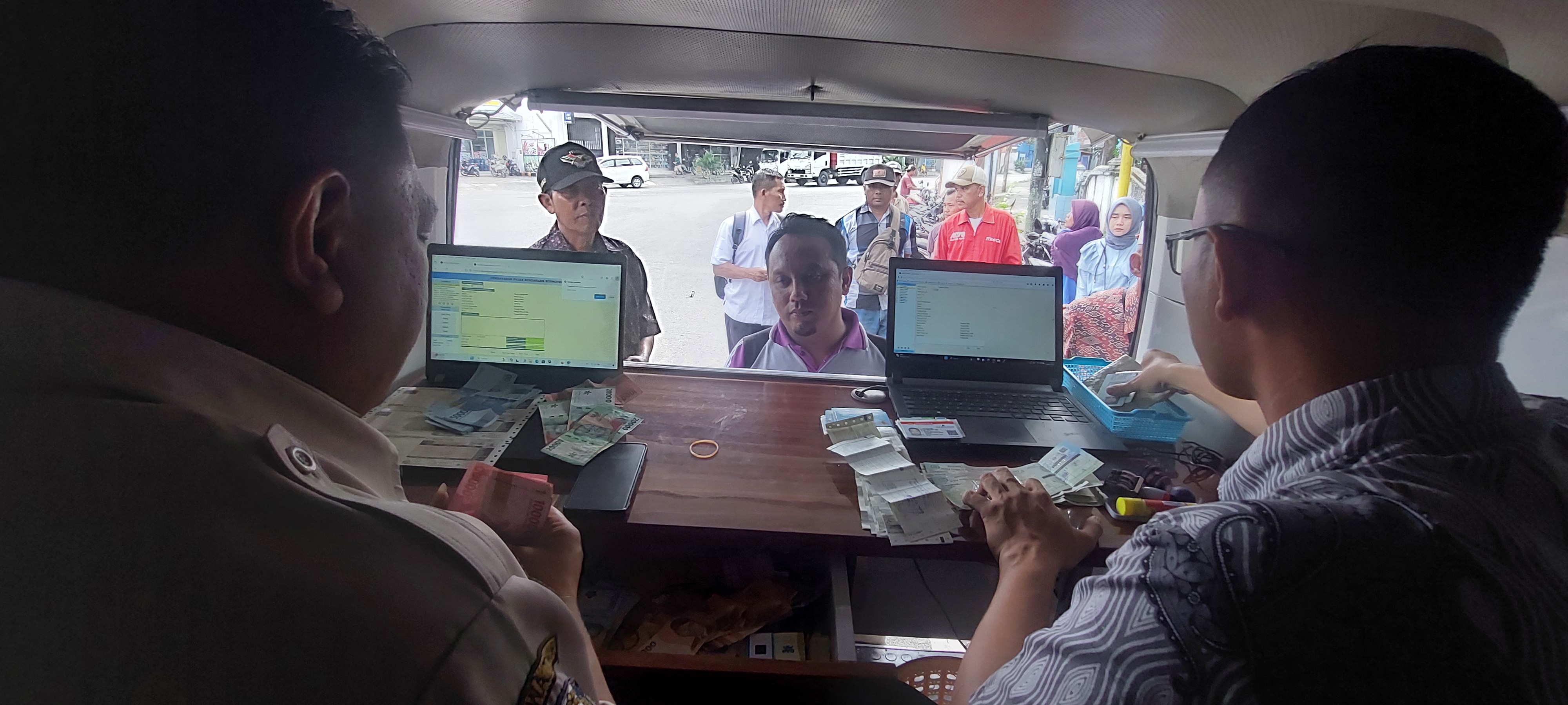 LAYANI SEPENUH HATI: Warga antusias membayar pajak kendaraan bermotor lewat mobil Samsat Keliling.(JUMAI/RADAR JEMBER)