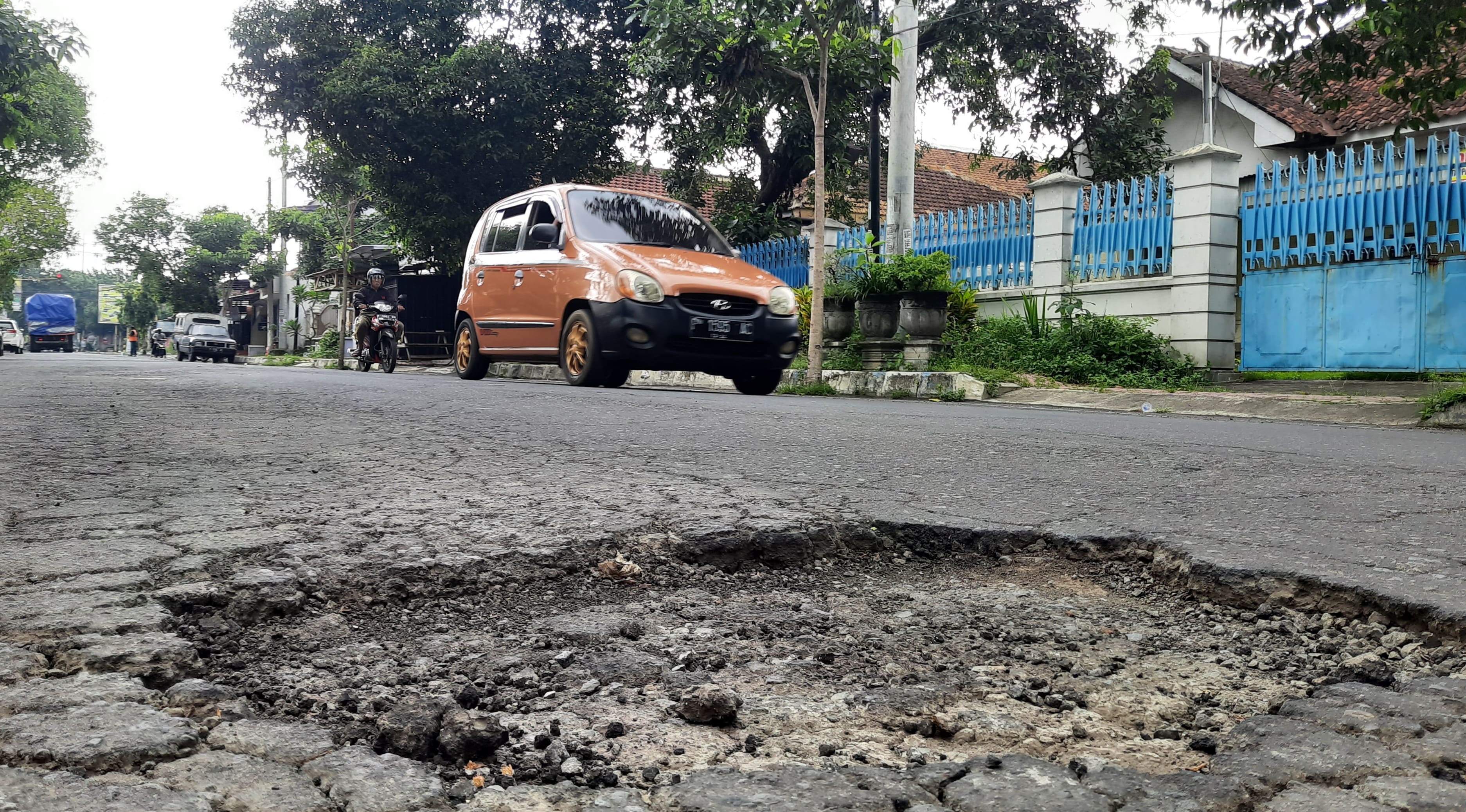 HARUS DIPERBAIKI: Kondisi infrastruktur jalan di Jalan Cipto Mangun Kusumo, Kelurahan Badean, banyak yang berlubang.(FAQIH HUMAINI/RADAR IJEN)