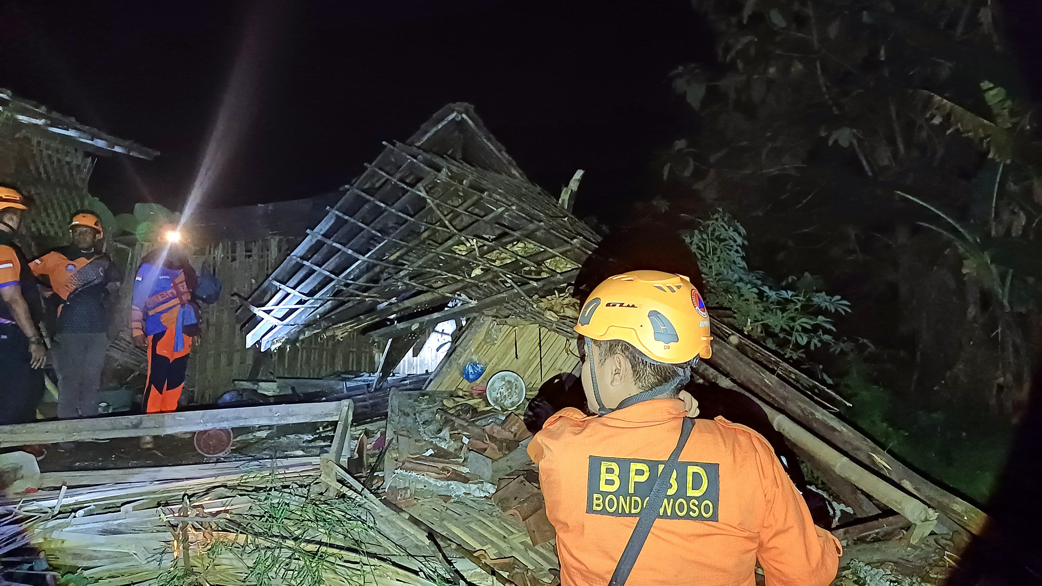 CEK LOKASI: Sejumlah petugas BPBD saat membantu warga membersihkan puing bangunan.(BPBD BONDOWOSO)