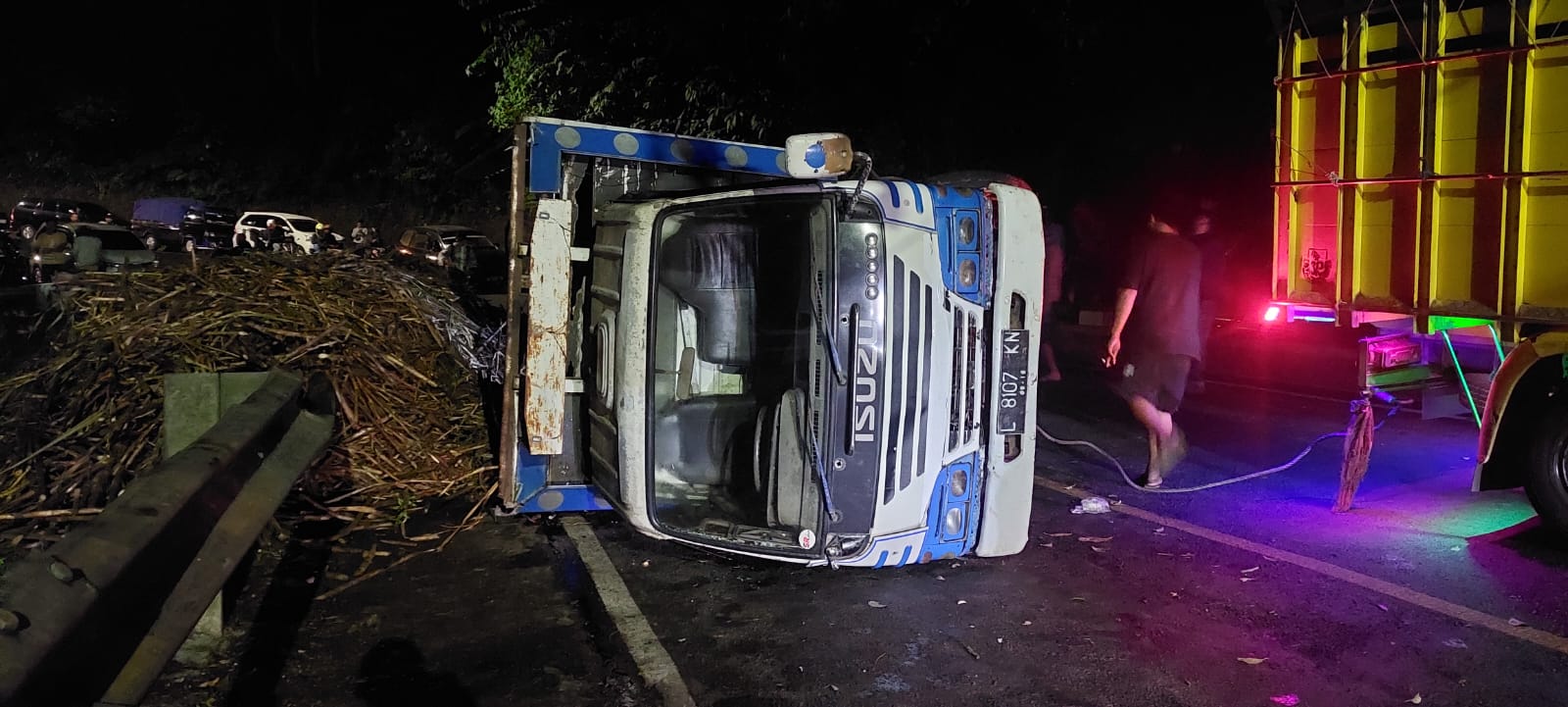 TERGULING LAGI: Truk bermuatan tebu yang hendak dikirim ke IGG, Kecamatan Glenmore, Banyuwangi kembali terguling di tikungan mbah Singo, Silo, Jember Senin (15/7). (JUMAI/RJ)