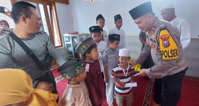 BERBAGI: Kapolsek Rambipuji Iptu Eko Yulianto menyerahkan santunan kepada 12 anak yatim, di Musala Iman dan Taqwa, Jumat (26/7). JUMAI/RADAR JEMBER