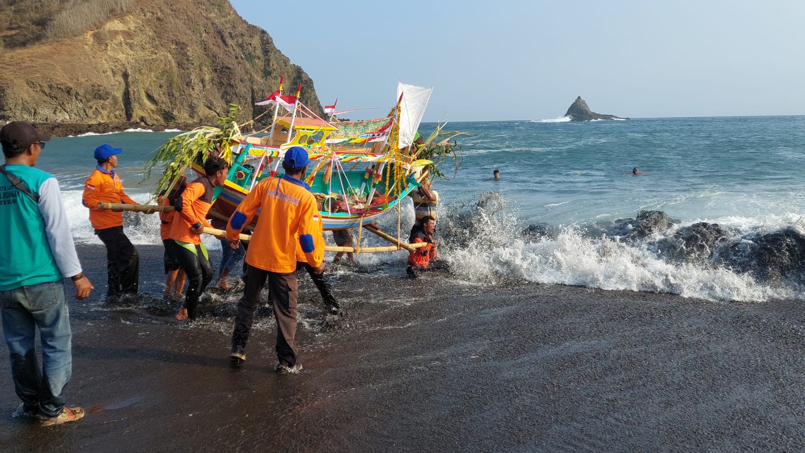 DILARUNG: Proses larung sesaji di pantai Payangan, Desa Sumberejo, Kecamatan Ambulu, Jember pada Jumat (2/8/2024) oleh tim SAR Rimba Laut. (Jumai/ Radar Jember)