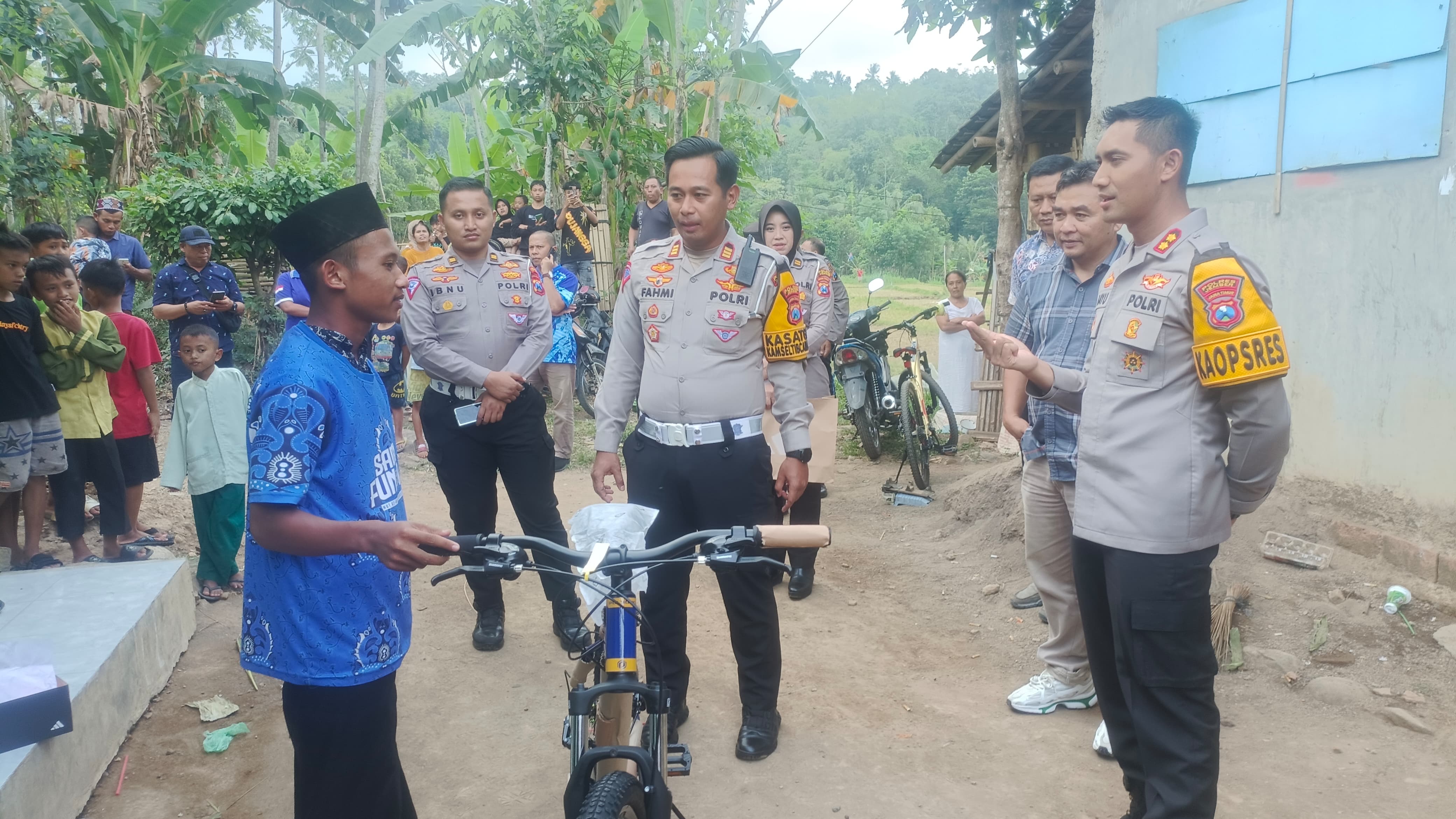 PEDULI: Kapolres Jember AKBP Bayu Pratama Gubunagi memberikan bantuan sepeda kepada Alif, siswa yang setiap hari berlari PP demi mengenyam pendidikan.