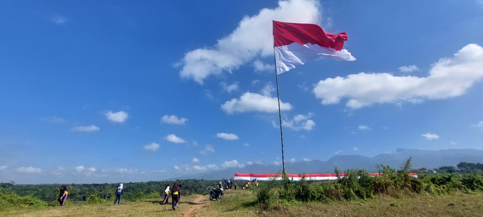 TERUS BERKIBAR: Bendera merah putih berukuran 10 X 8 meter dikibarkan oleh Muspika Patrang di Kelurahan Bintoro, Kecamatan Patrang, kemarin (6/8).(JUMAI/ RADAR JEMBER)