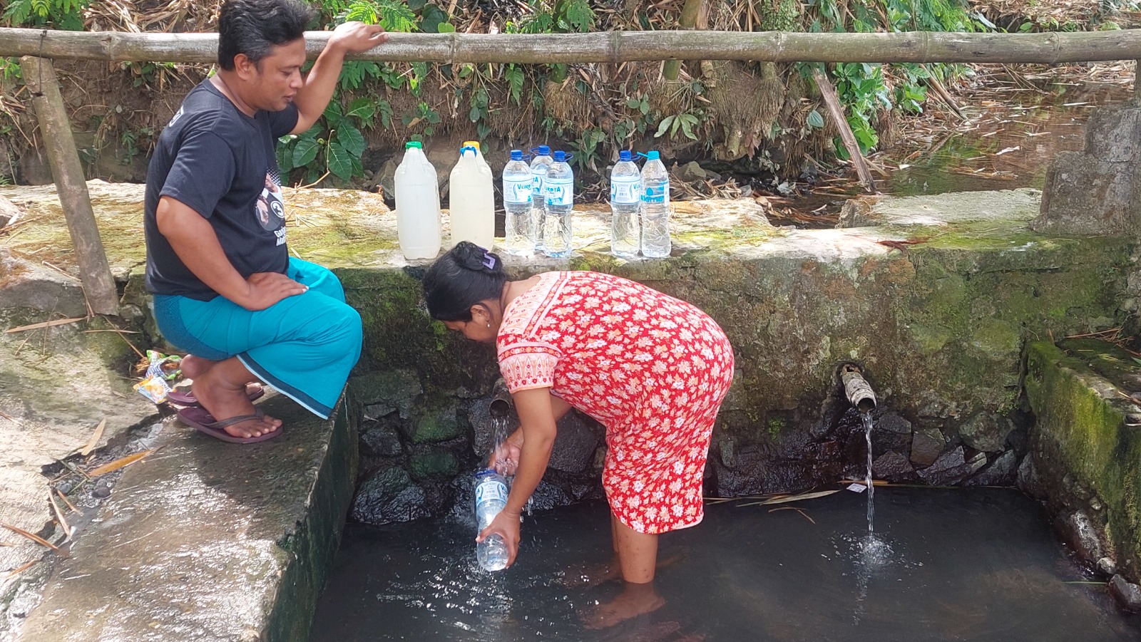 MANFAATKAN SUMBER AIR: Warga Dusun Krajan, Desa Plalangan, Kecamatan Kalisat, mengambil air bersih di Mata Air Dringu untuk memenuhi kebutuhan minum dan memasak, kemarin. (JUMAI/RADAR JEMBER)