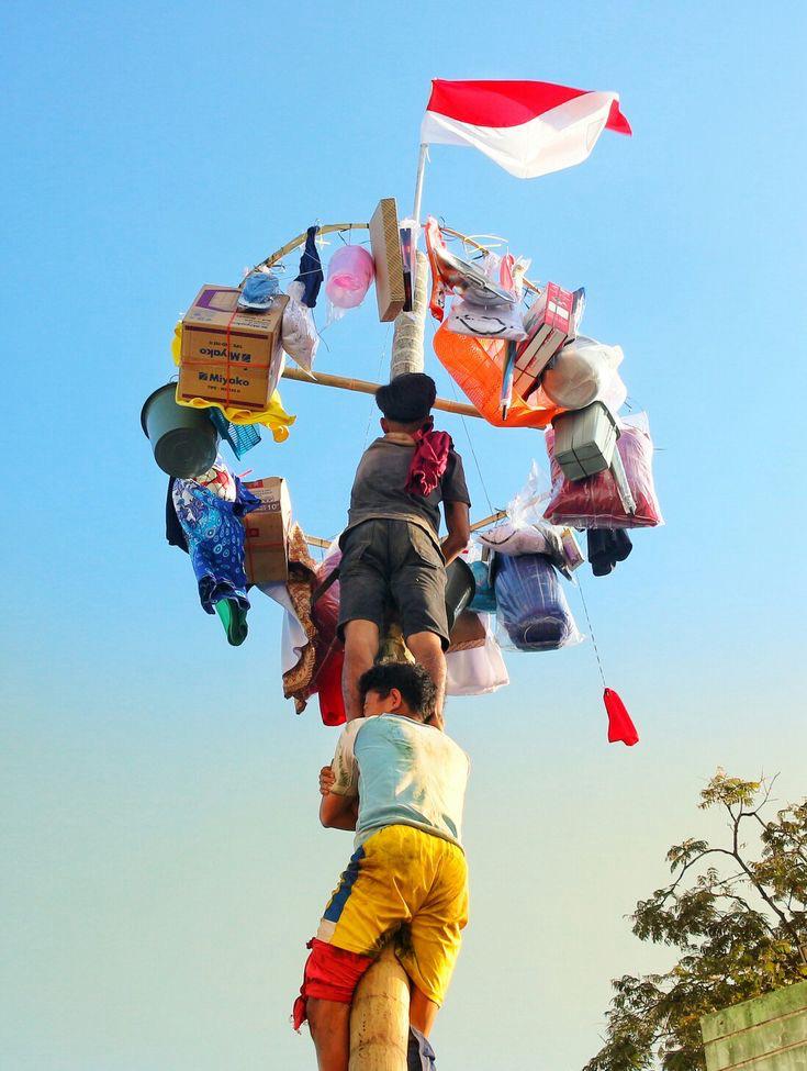 KOMPAK: Pemain panjat pinang saling bekerjasama untuk bisa mencapai puncak ketinggian merebut hadiah.