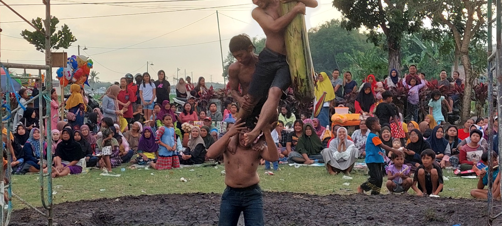 KOMPAK: Peserta panjat pohon pisang yang diadakan Lingkungan Karanganyar, Kelurahan Tegal Besar, Kecamatan Kaliwates.(JUMAI/ RADAR JEMBER)