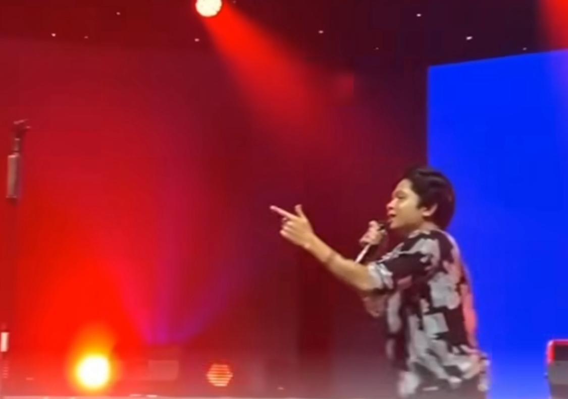 Tangkapan layar salah satu musisi saat manggung dengan menampilkan gambar burung garuda warna biru.