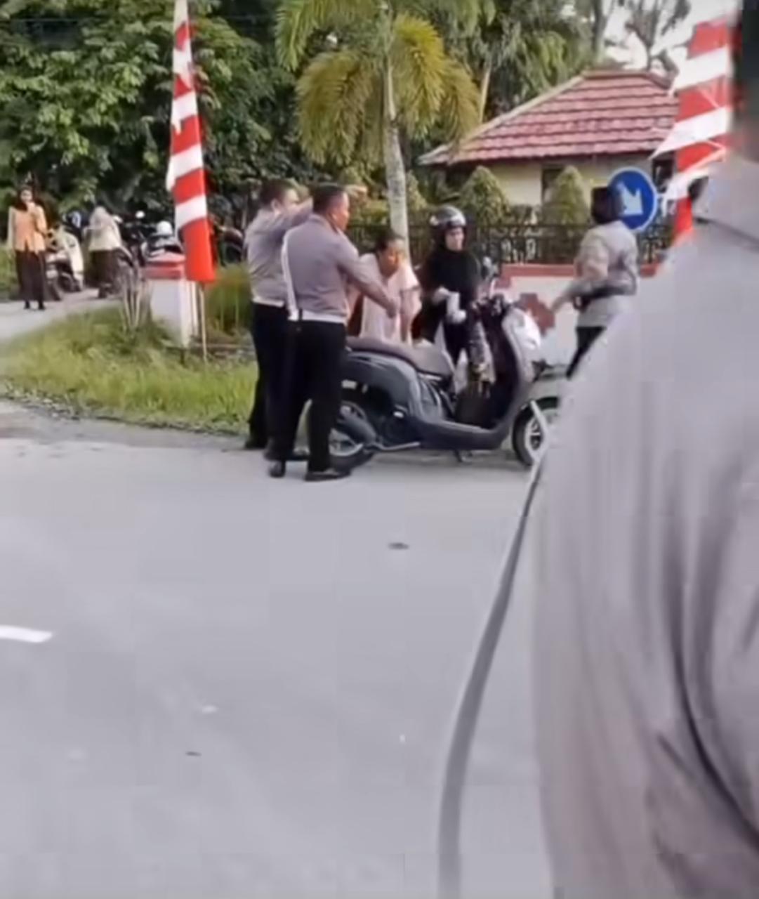 Hasil tangkapan layar seorang polisi dan polwan hendak menolon ibu melahirkan