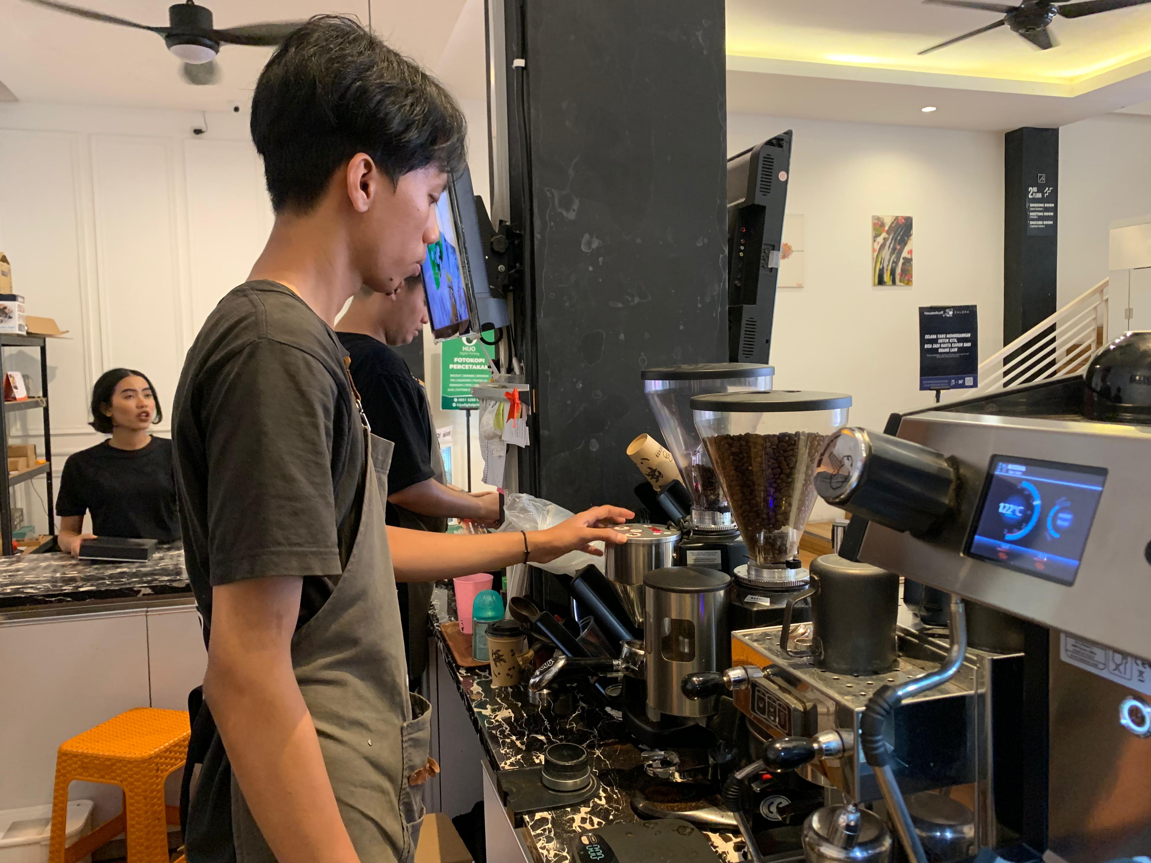 RACIK KOPI: Rizanta Pilano ketika meracik kopi untuk melayani pengunjung. (Ayin Tripuan Maharani/RADAR JEMBER)