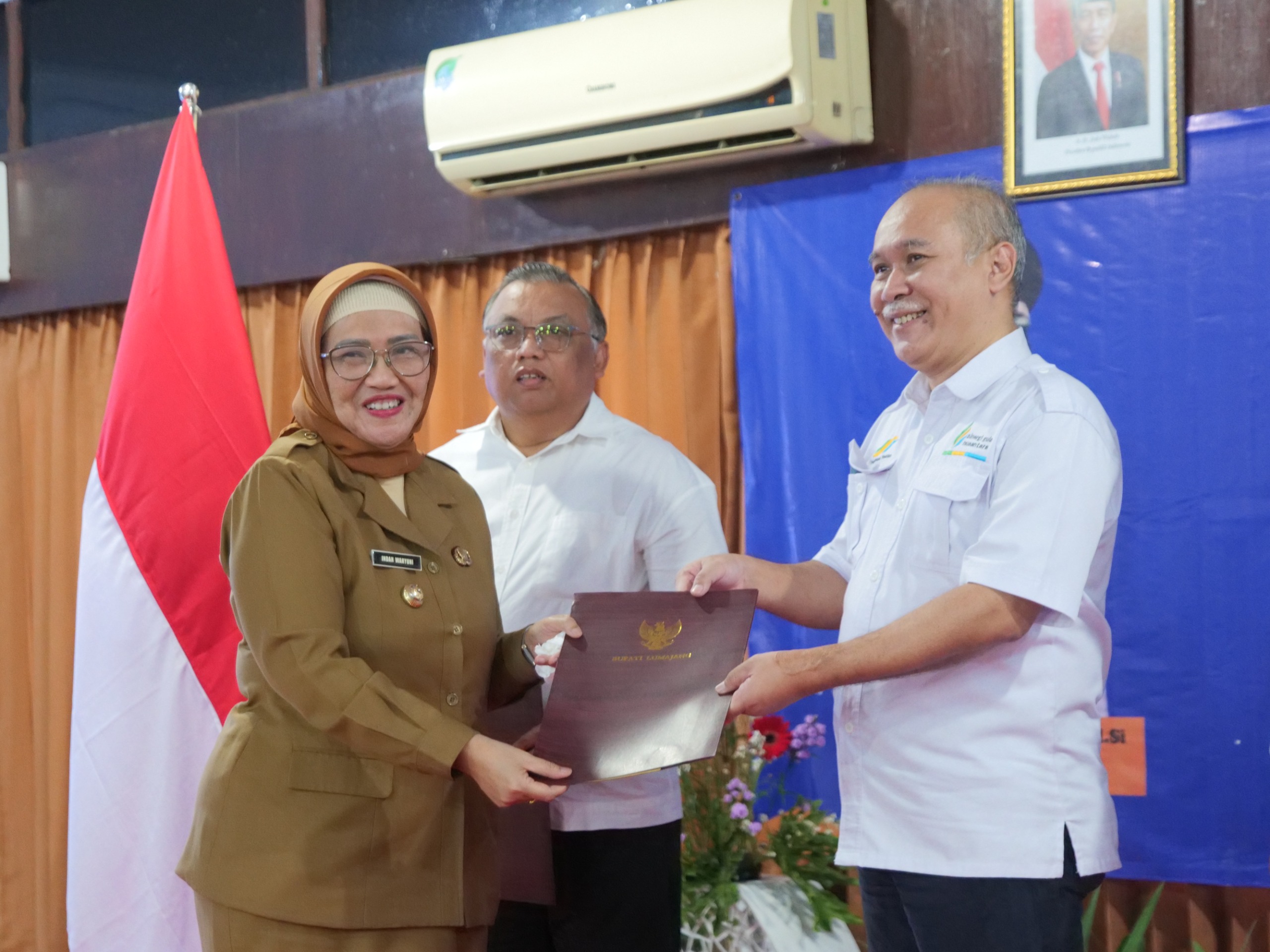 PEMBEBASAN: Pj Bupati Lumajang Indah Wahyuni (kiri) menyerahkan SSPD BPHTB kepada GM PG Jatiroto Agus Priambodo (kanan).
