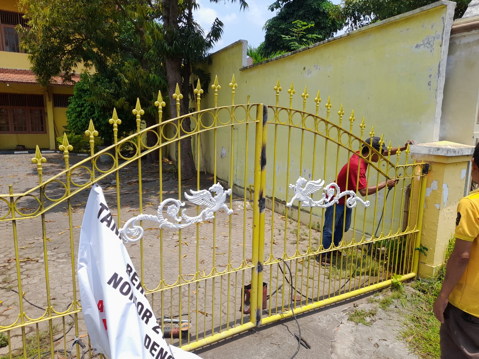 LAS: Sejumlah tukang las yang didatangkan ahli waris A. Munif Basyuni saat mengelas gerbang pintu masuk dan gerbang pintu keluar DPD Golkar Lumajang, kemarin. (ATIEQSON MAR IQBAL/RAME)