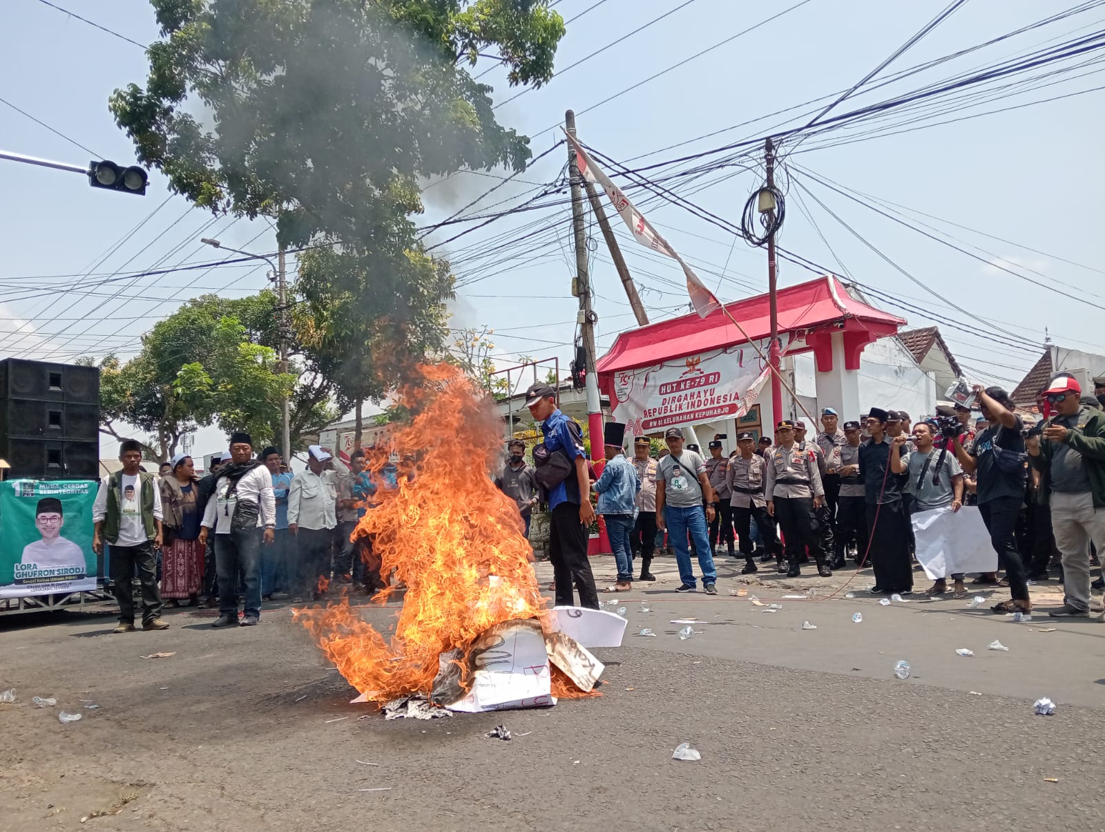 AKSI: Sejumlah massa aksi pendukung Ach. Ghufron Sirodj saat membakar ban di depan kantor KPU Lumajang, mereka menuntut surat keputusan penggantian dibatalkan. (ATIEQSON MAR IQBAL/RAME)