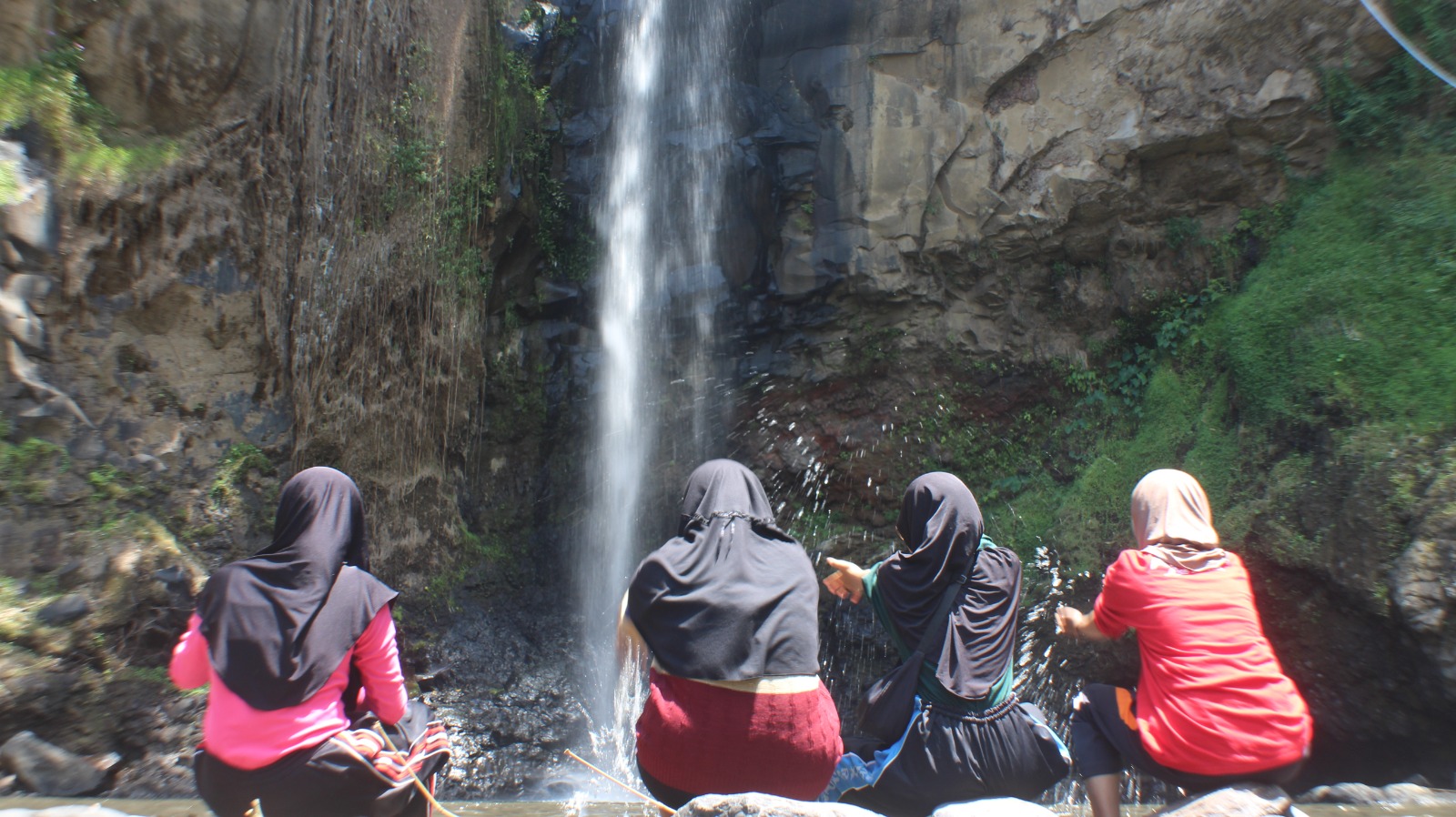 JADI WAHANA: Pengunjung air terjun Sarun tampak asik bermain air di sungai kecil yang ada di bawahnya.