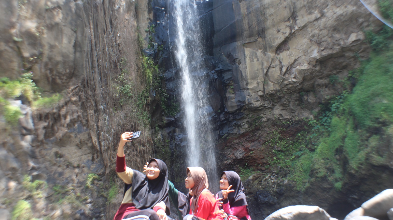 SWAFOTO: Beberapa pengunjung melakukan swafoto di sejumlah spot estetik di Air Terjun Sarun. (MUHAMMAD HASBI/RADAR SEMERU)