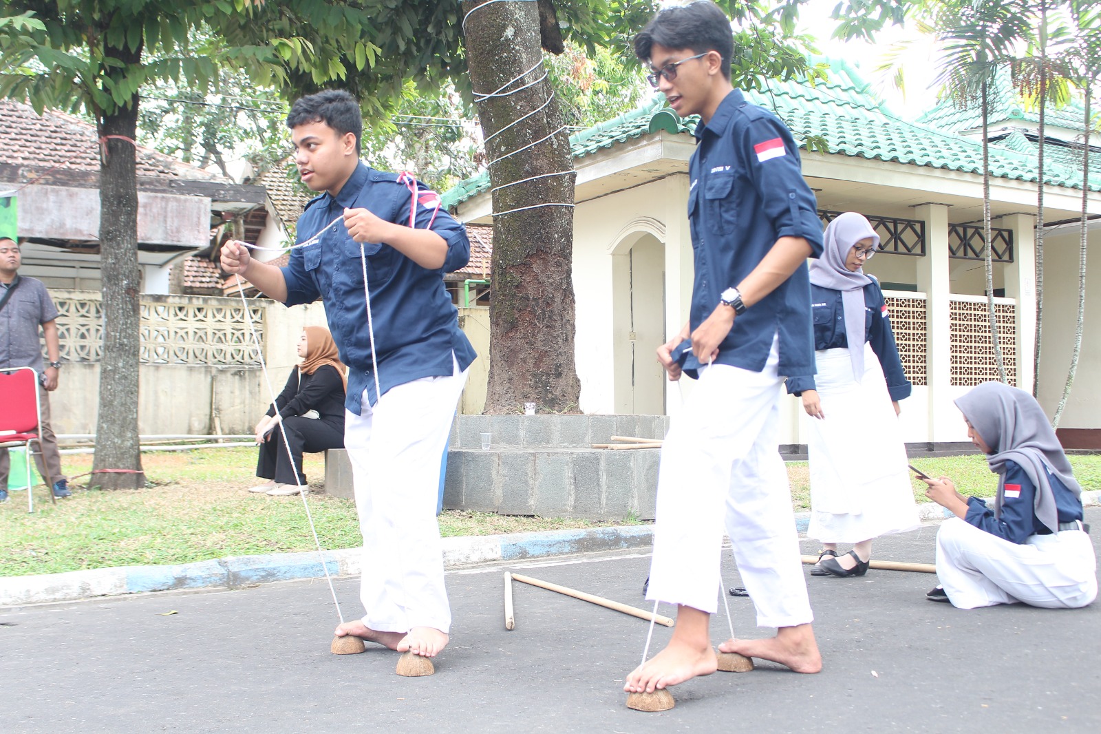 TRADISIONAL: Hussein Al-Haddar dan Ananta Haekal Ghailan Prasetiasaat bermain egrang bersama.(HILMI BASKORO/RADAR IJEN)