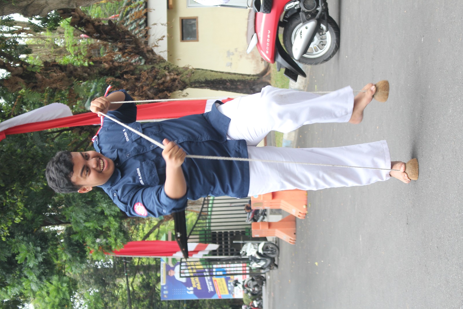 LATIH KESEIMBANGAN: Haekal memastikan talinya kencang untuk memudahkannya berjalan.(HILMI BASKORO/RADAR IJEN)