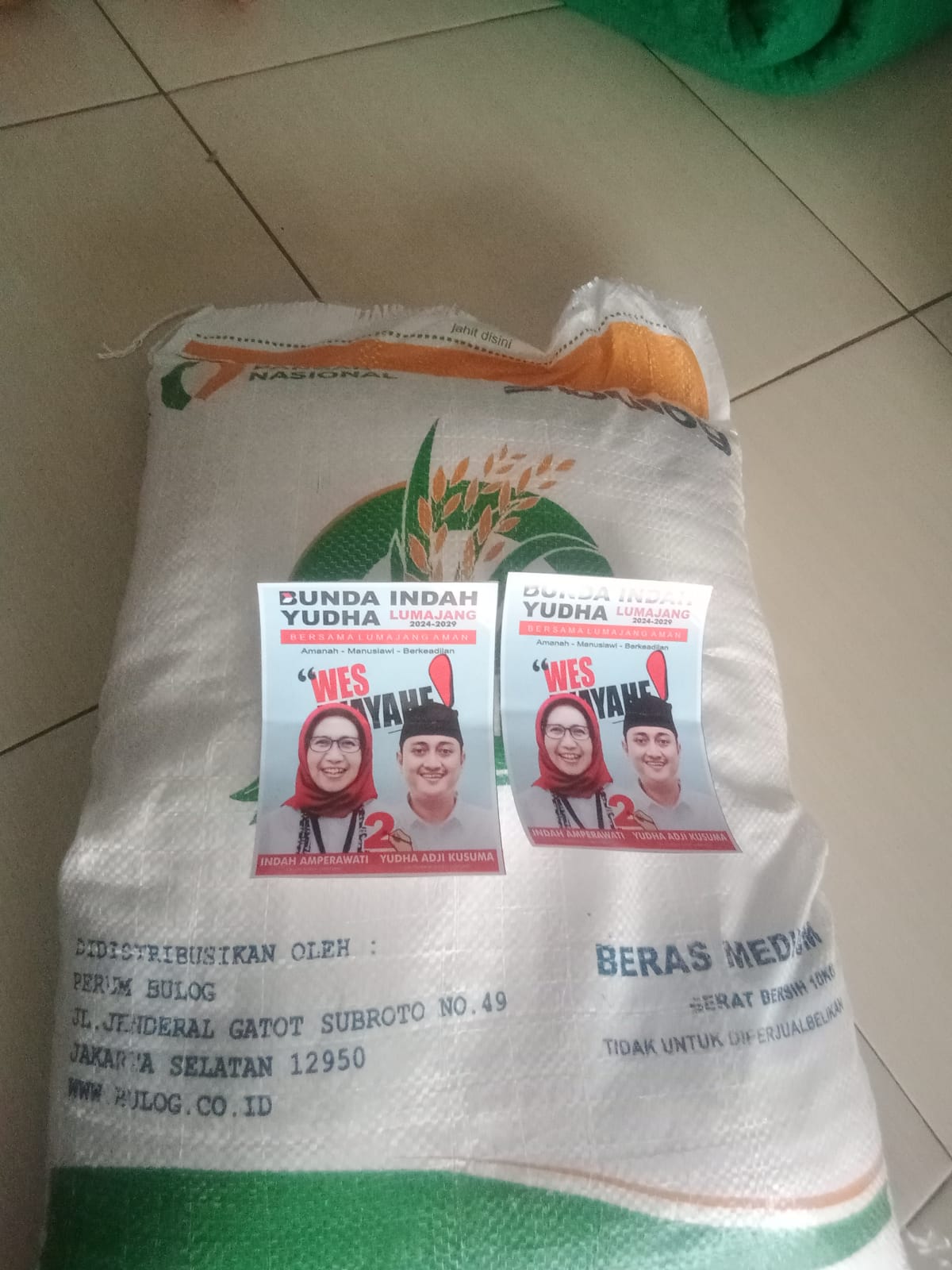 DIKASIH: Stiker salah satu pasangan calon pilkada Lumajang yang diberikan stiker saat penyaluran bantuan sosial (bansos) cadangan beras pemerintah (CBP) berupa beras 10 kilogram. (NETIZEN FOR RAME)