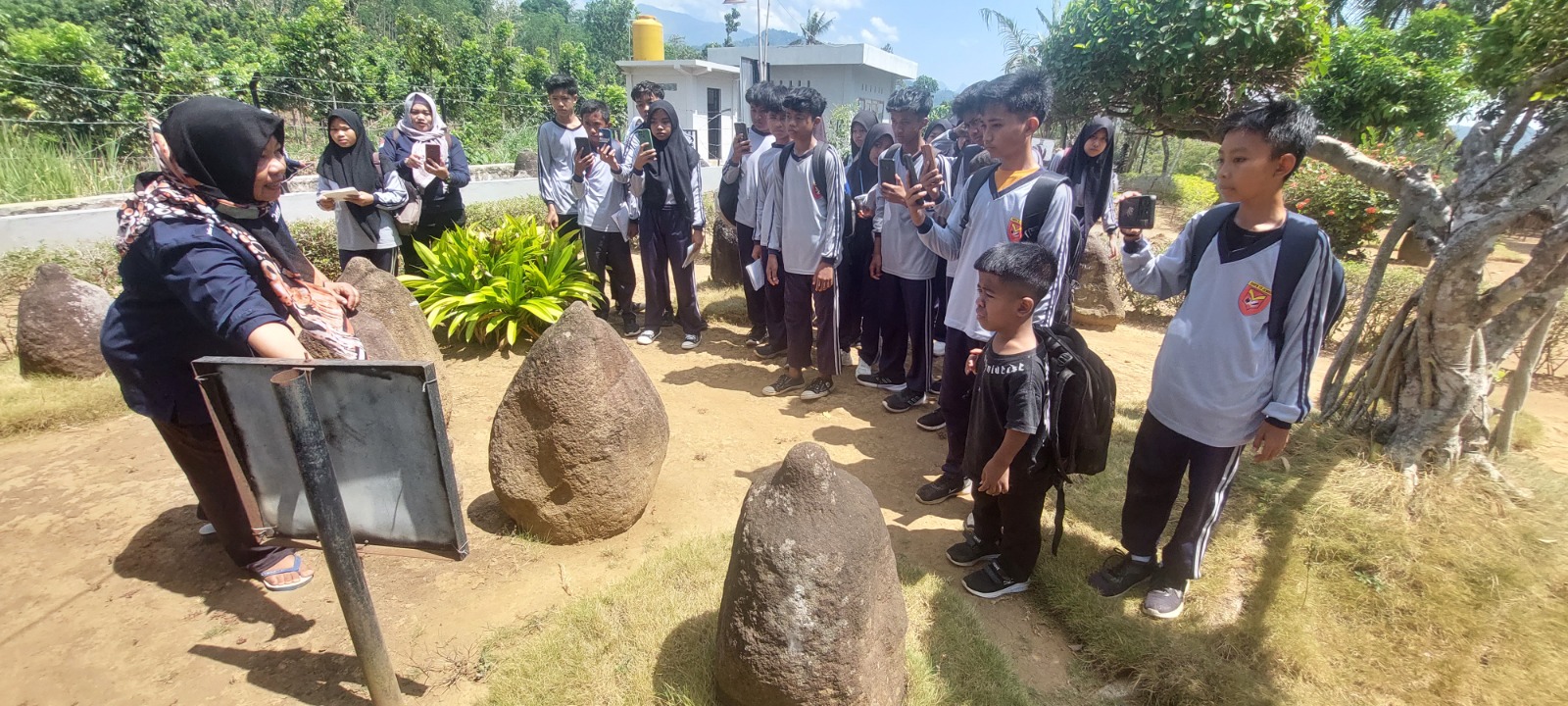 DAPAT PENGALAMAN: Sejumlah siswa SMPN 15 Jember Ketika mendapat penjelasan langsung oleh juru pelihara di Situs Duplang, Arjasa.(JUMAI/RADAR JEMBER)