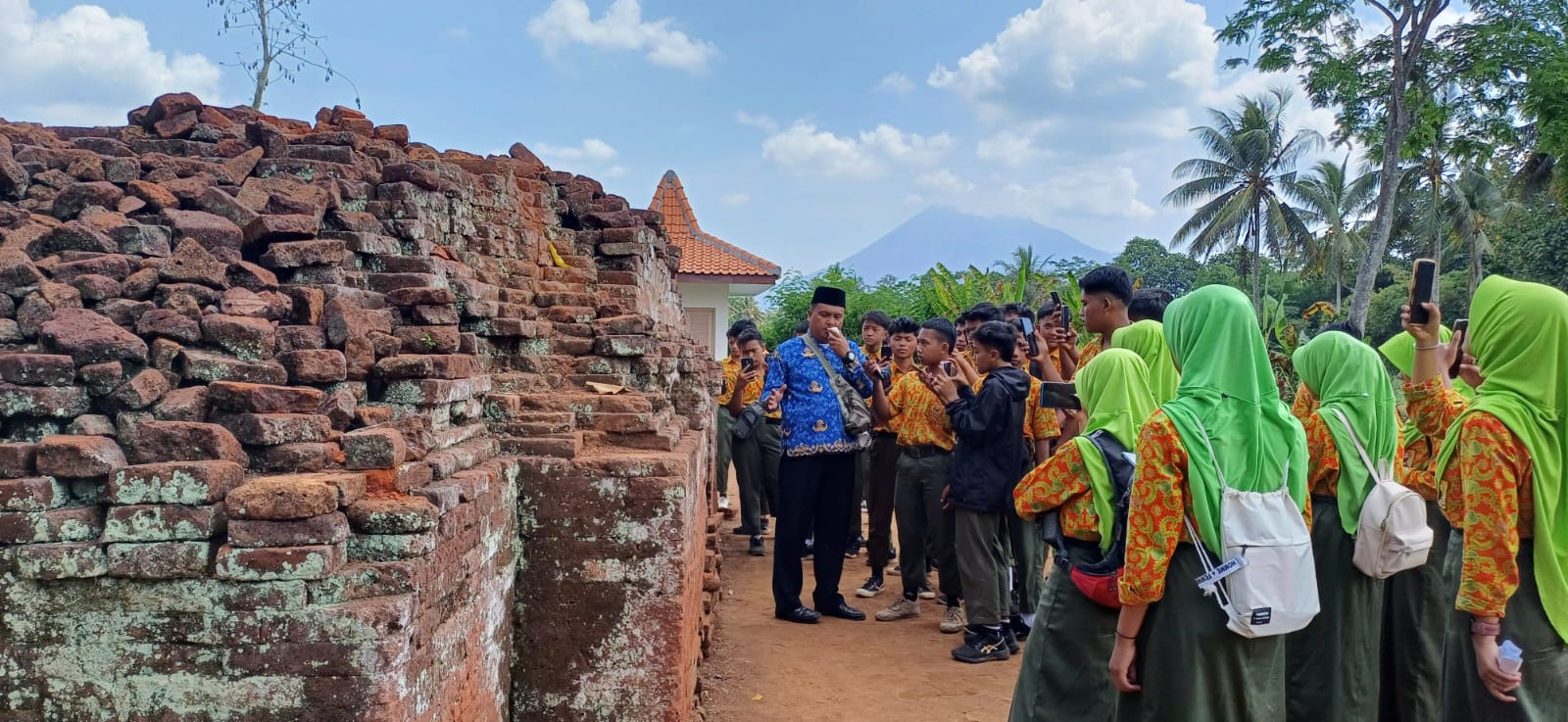 KUNJUNGAN: Siswa-siswi Lumajang ketika mengunjungi candi agung di Desa Randuagung. Mereka tampak asik belajar sejarah dan budaya lokal. (DISKOMINFO LUMAJANG)