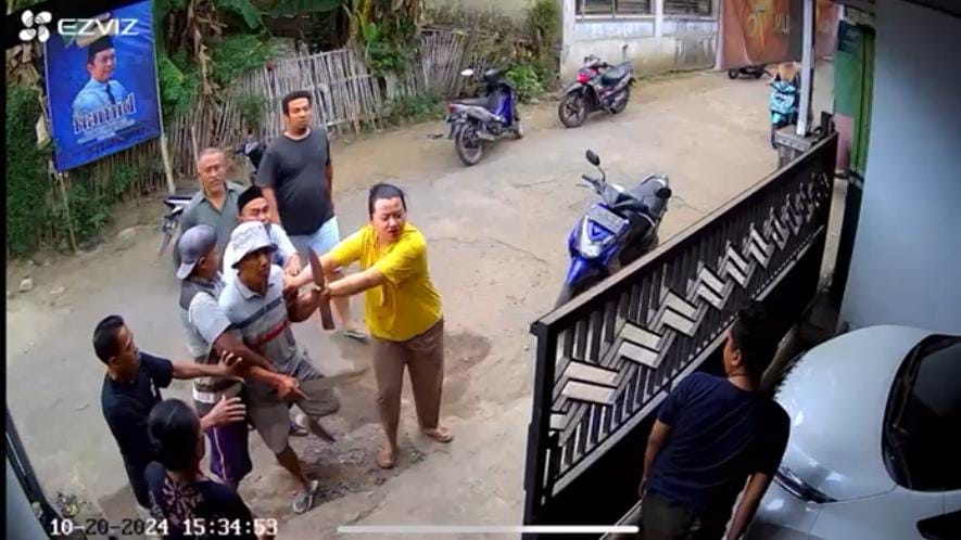 BAWA PARANG: Tangkapan layar video detik-detik S mendatangi rumah Faizi sambil membawa parang, yang terekam CCTV.